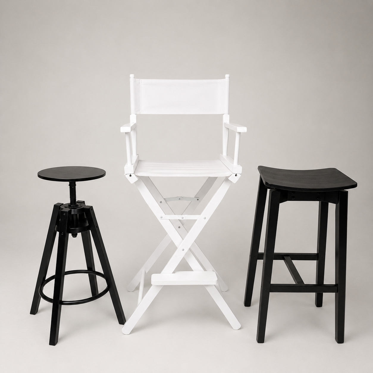 Schwarzer Industriehocker weißer Regisseursstuhl und schwarzer Holzhocker als Requisiten für Foto und Video Produktionen – Fotostudio Aesthetic Space München
