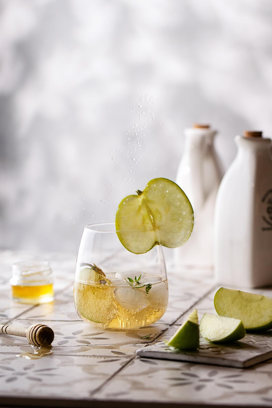 Apfel Schorle mit Eiswürfel und Honig dekoriert mit Apfelscheibe 