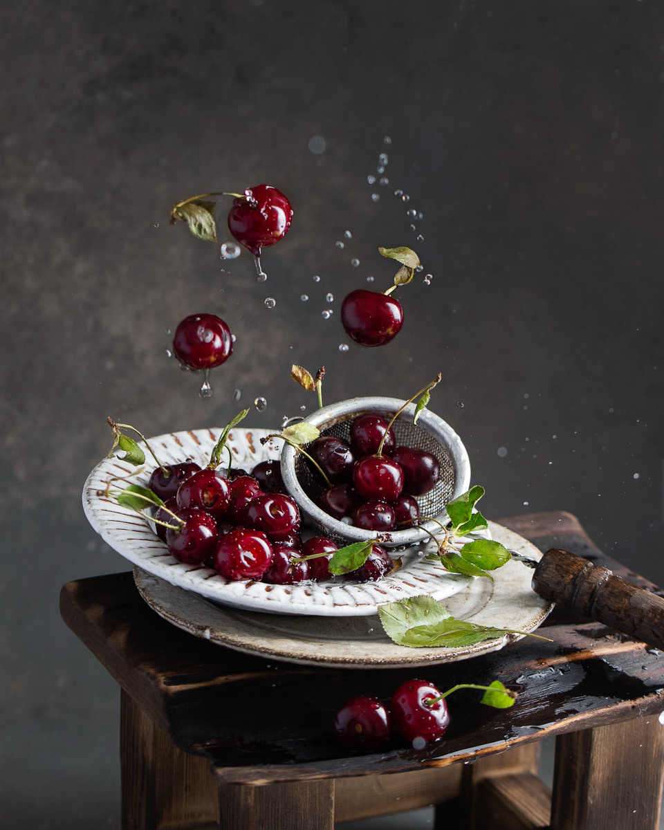 Fliegende Kirsche auf dem Teller Action Foto mit Tropfen