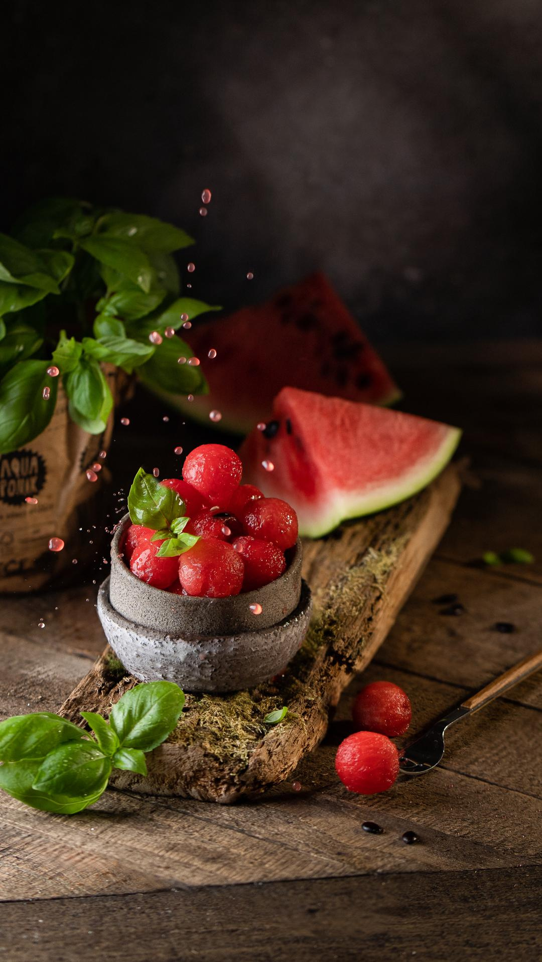 Food Styling Wassermelonen in Kugelform mit Minze auf dem Holzbrett