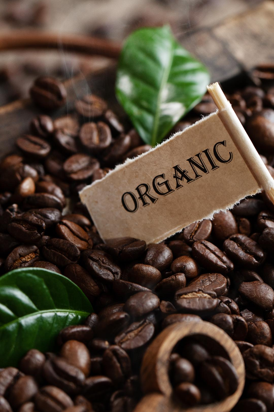 Stimmungsvolles Foto mit Kaffeebohnen und grünen Kaffeeblättern in einer Holzkiste