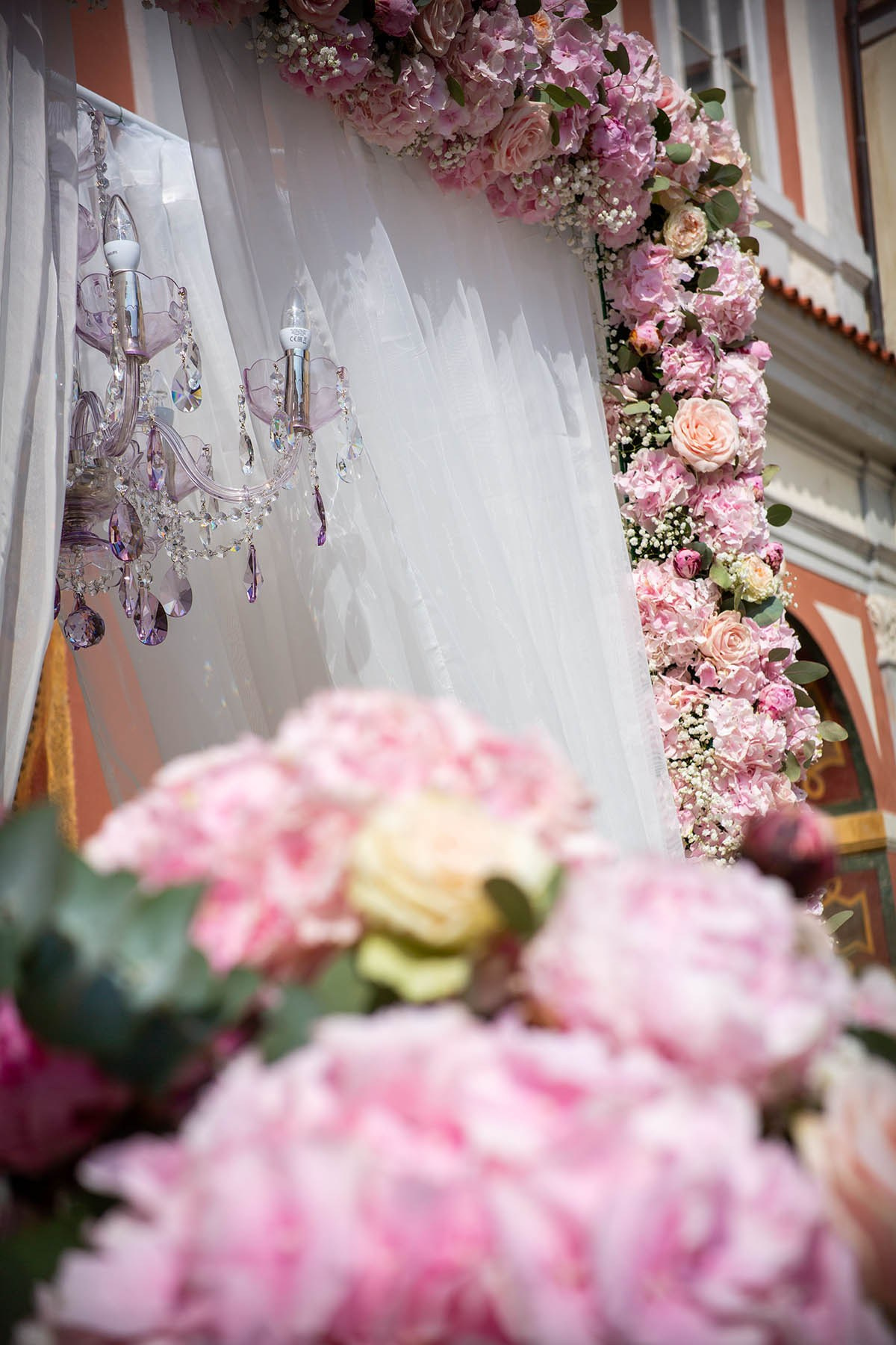 For the wedding arch, roses were used to adorn the archway, and a crystal chandelier was suspended in the center.