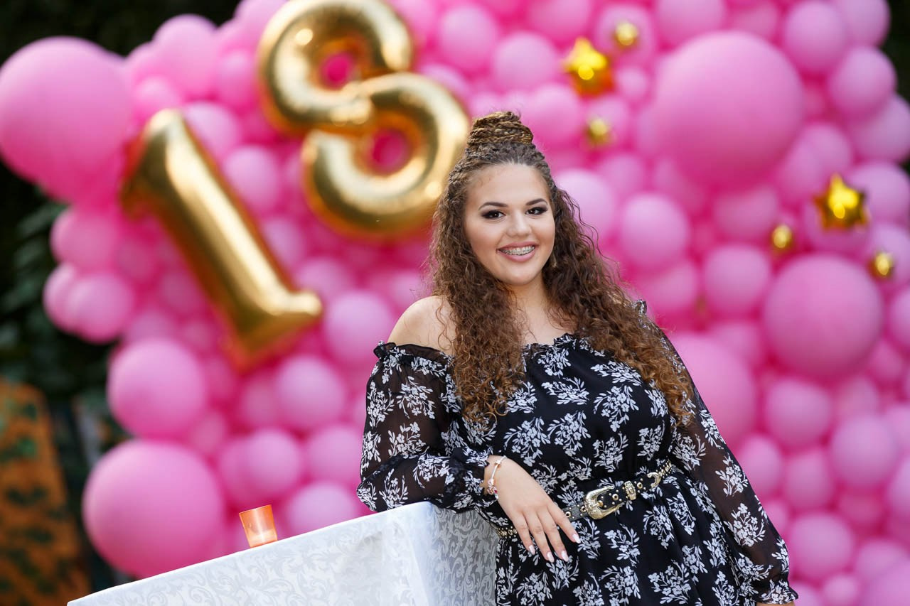 Portret slavljenice sa ružičastim balonima – profesionalna fotografija punoletstva.