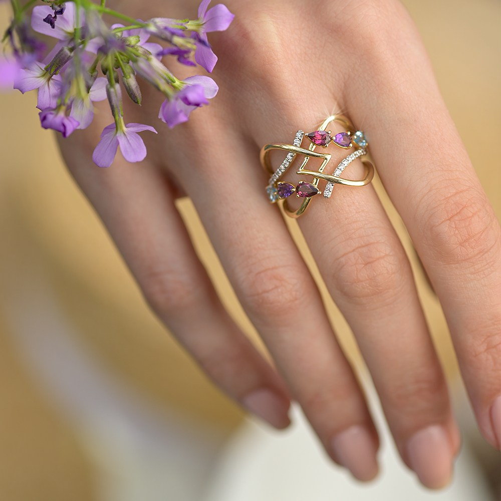 Zlatni prsten na ruci devojke sa cvetićima.