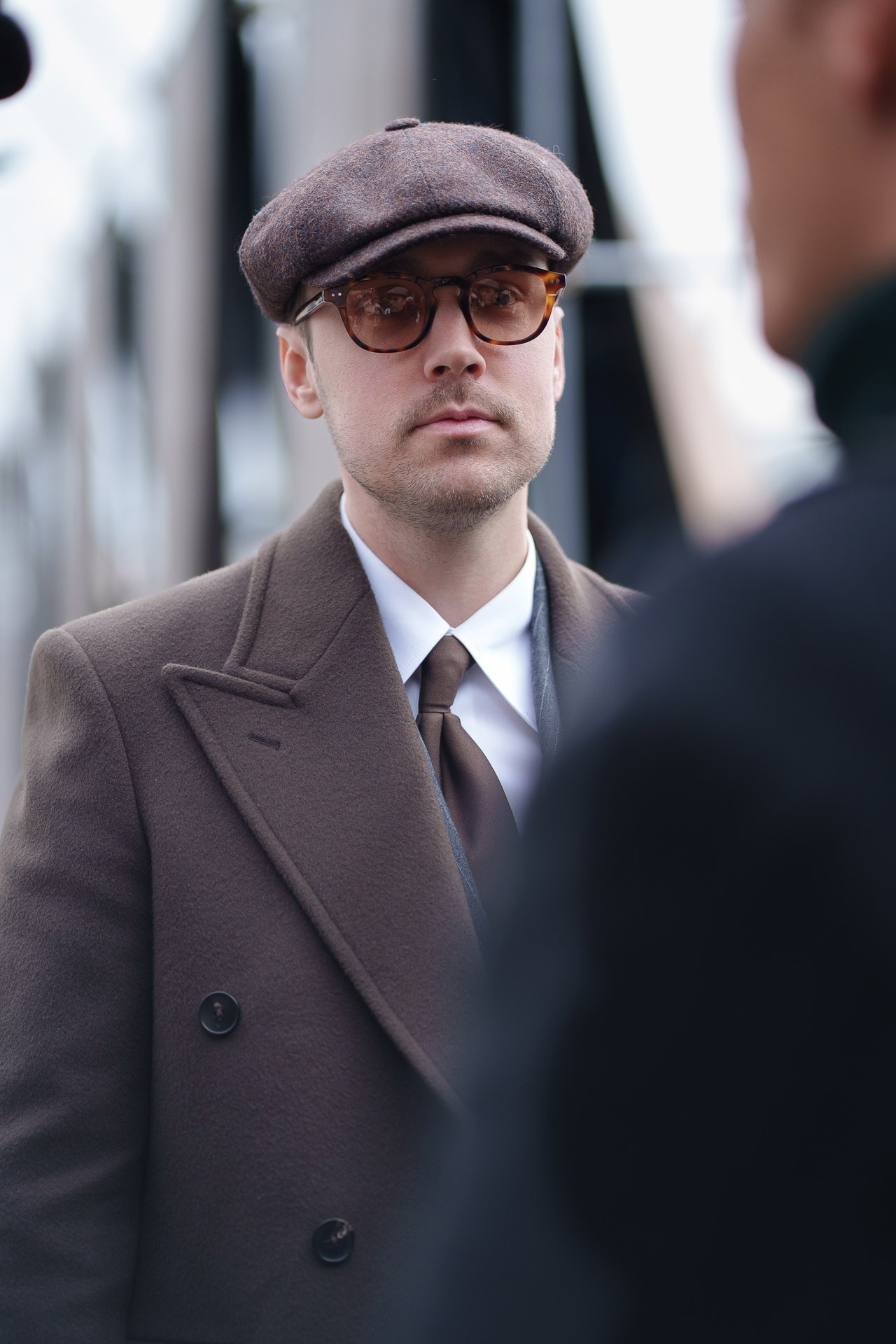 Man in brown suit and flat cap at Pitti Uomo 109 street style portrait
