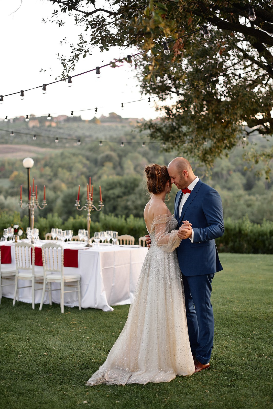 Candlelit wedding reception in Tuscany — romantic evening atmosphere with stone architecture and warm golden light