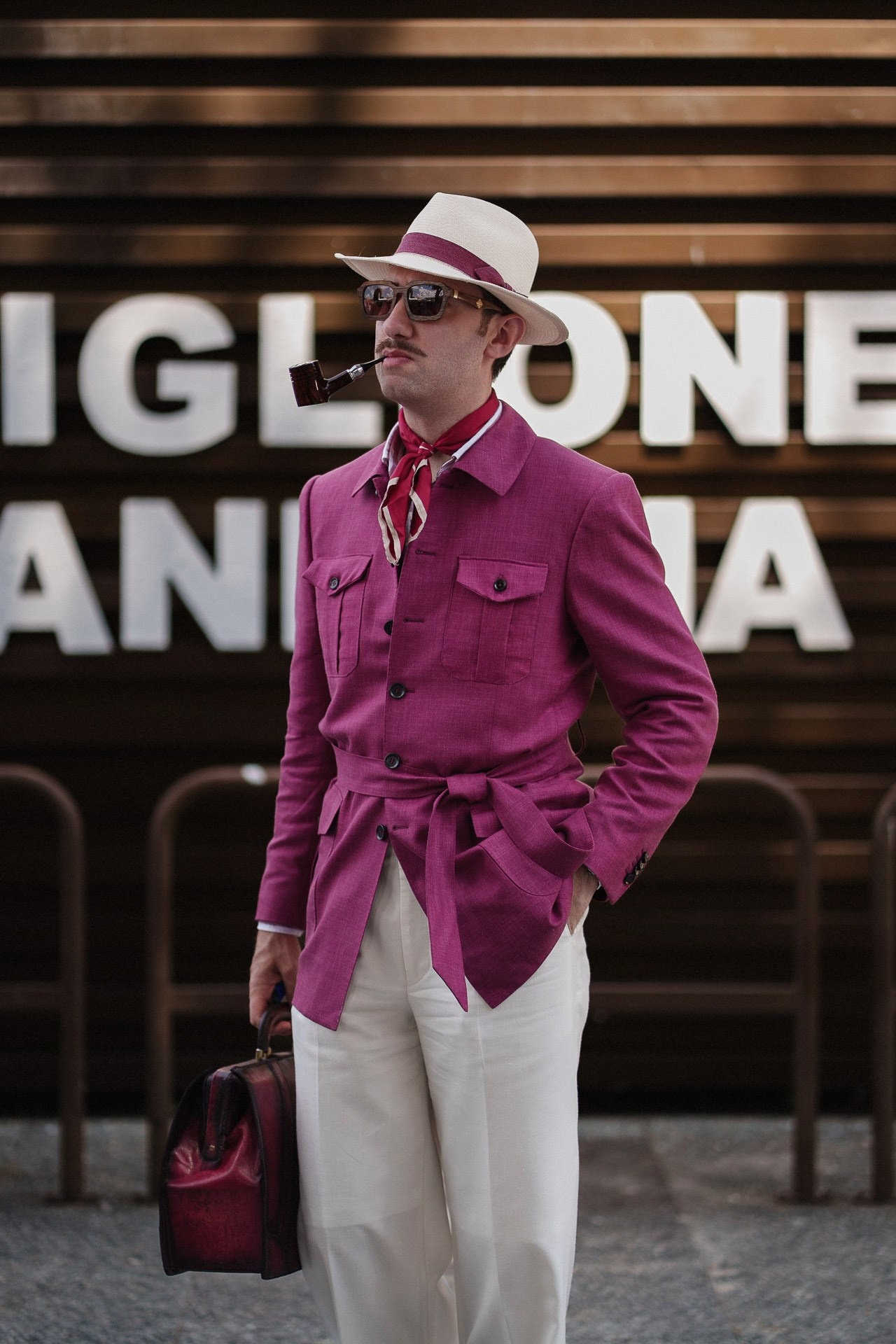 Pitti Uomo 110 street style, guest in magenta jacket, white trousers and straw hat near Fortezza da Basso