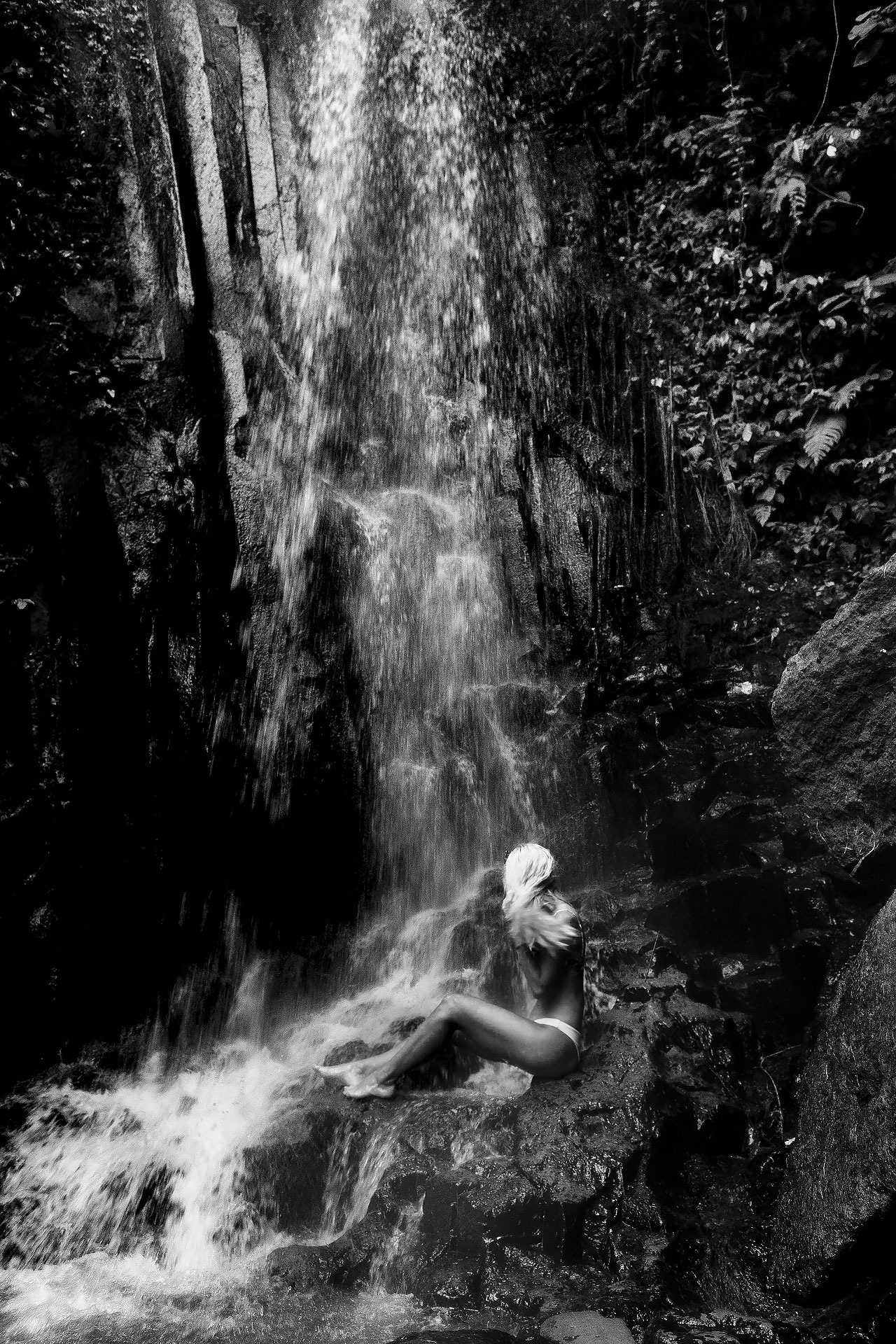 portrait of the lady sitting near the waterfall in the jungles of Bali island 