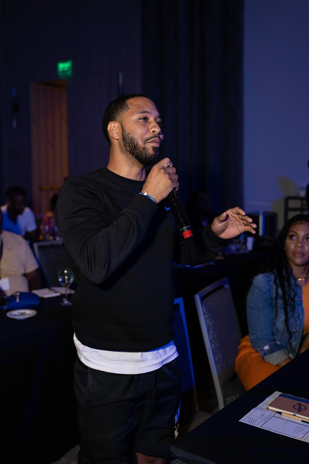 Participant holding microphone while asking question during session.