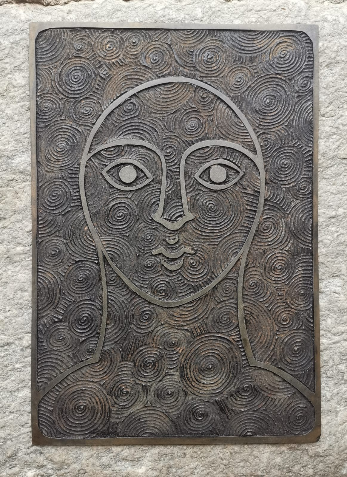 In Santi Volti, Nadia Kuprina explores the theme of the icon through seriality and material stratification. The work originates from the repetition of three original linocuts, hand-printed in gold, and is subsequently transformed through hand stitching, oil painting, and applications of gold leaf.Its exhibition history — two abbey settings and one winery — highlights the versatility of the work, capable of engaging with spiritual, architectural, and unconventional exhibition spaces. The publication in a catalogue reinforces its curatorial relevance and the solidity of the artist’s trajectory.