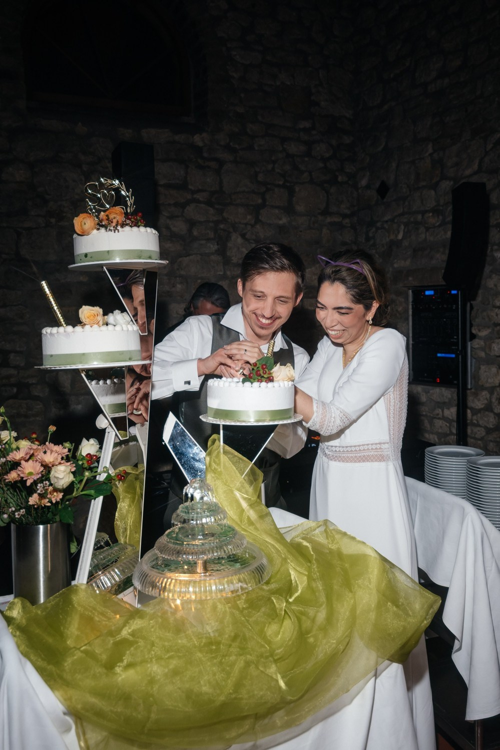 bride and groom are cutting wedding cake