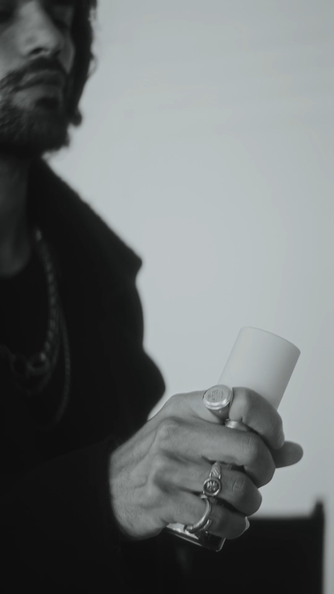 Close-up of hands holding a skincare product, blending fashion and beauty storytelling.