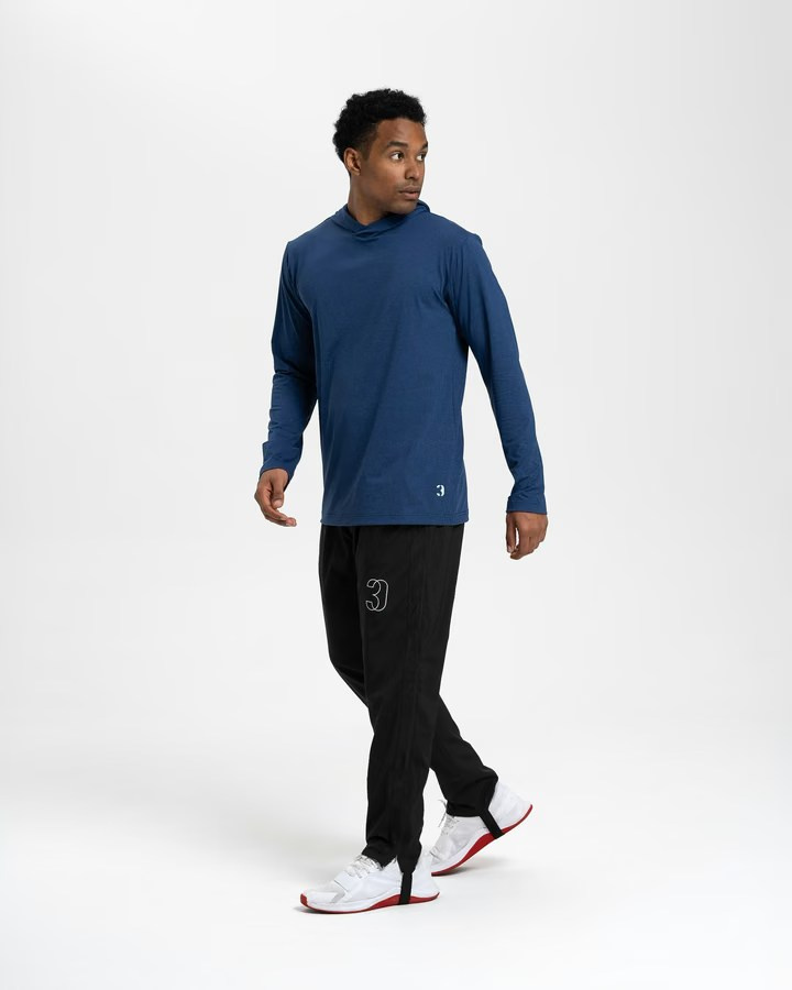 Full-body e-commerce photo of a man in athletic wear posing against a white background