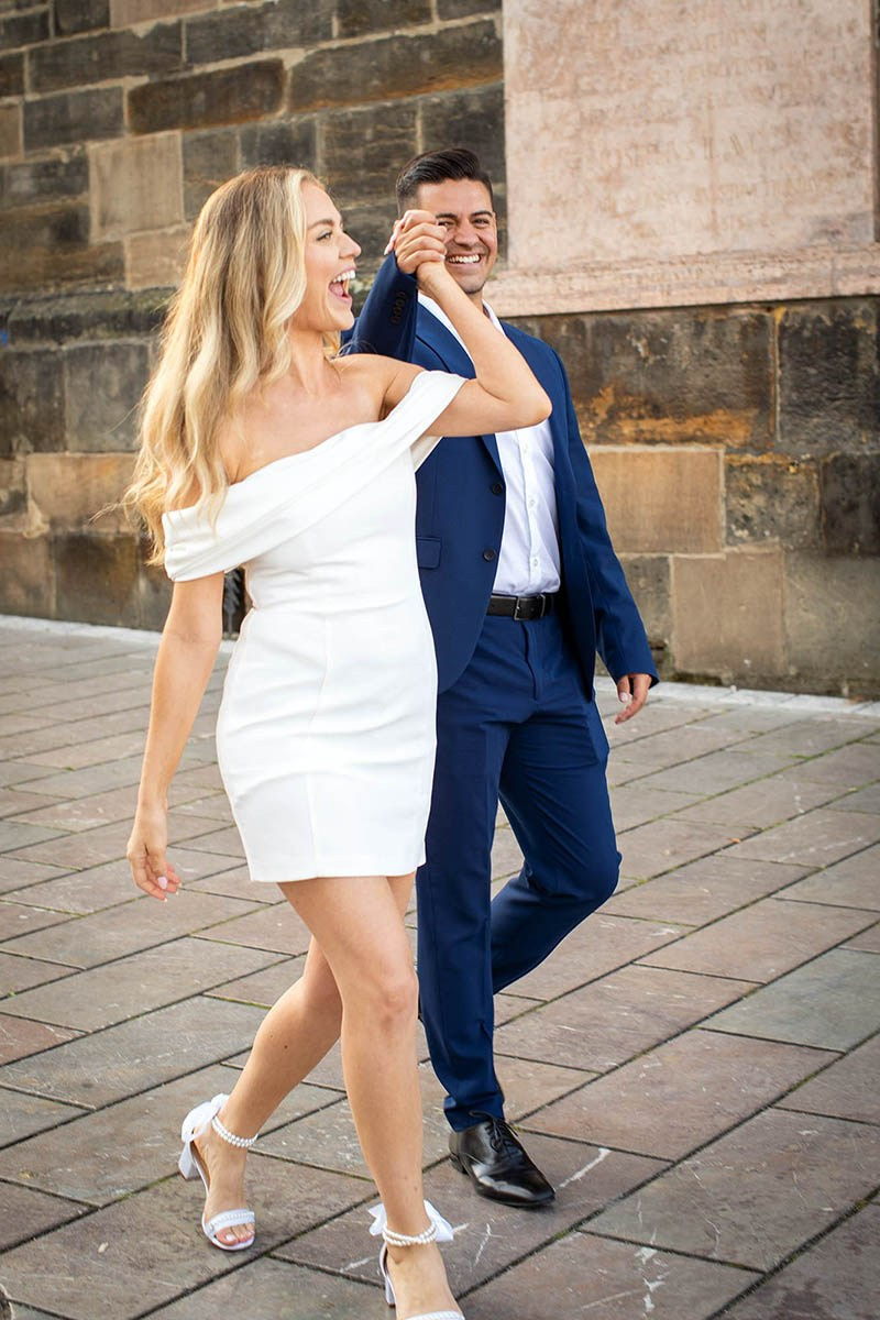 An American couple hand-in-hand Charles Bridge sunrise walk