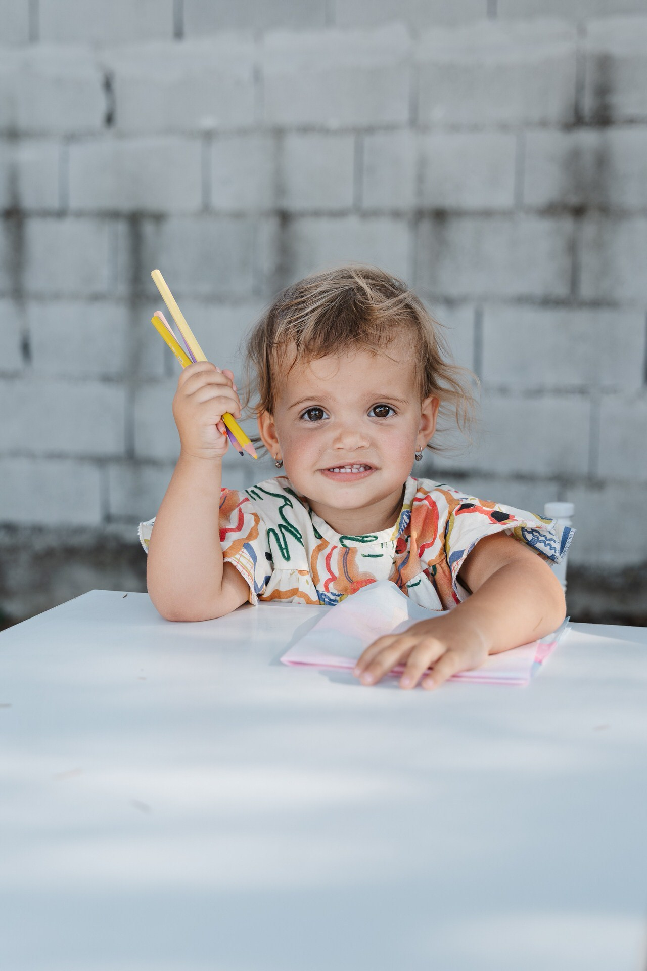 Beba pozira fotografu držeći štapiće za jelo.
