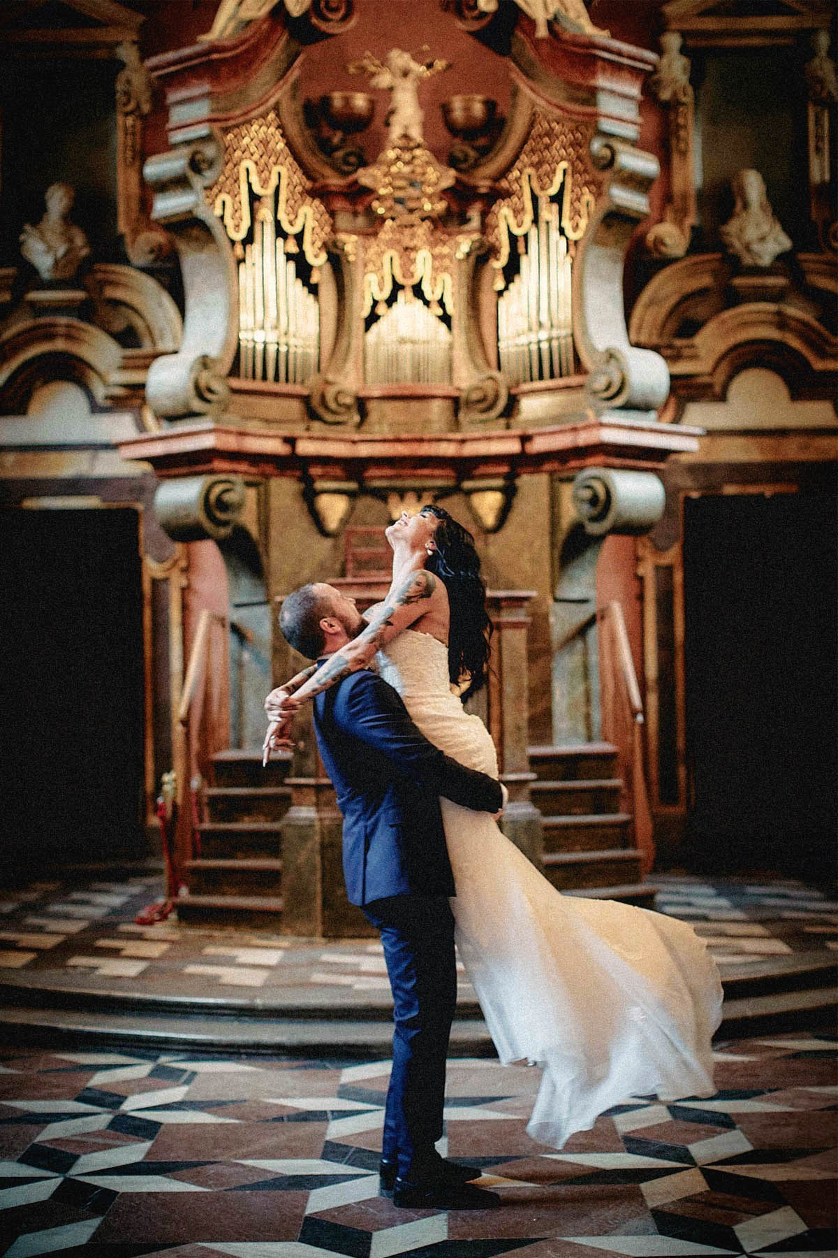 Groom spinning tattooed bride in Mirror Chapel, Klementinum wedding