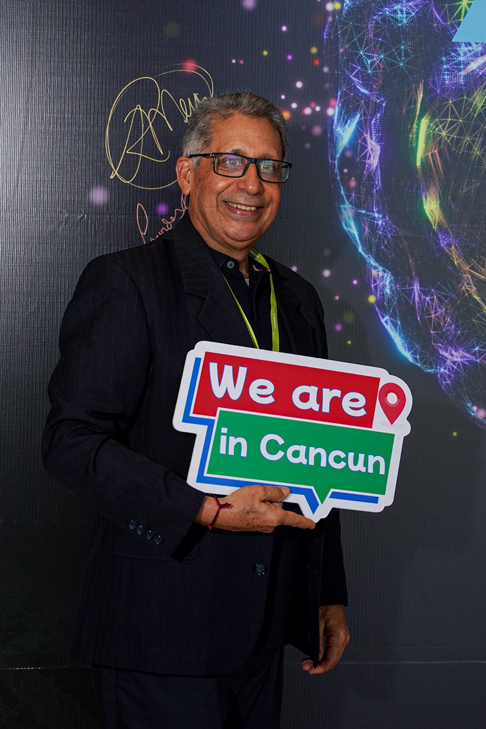 Portrait of participant against conference venue backdrop.