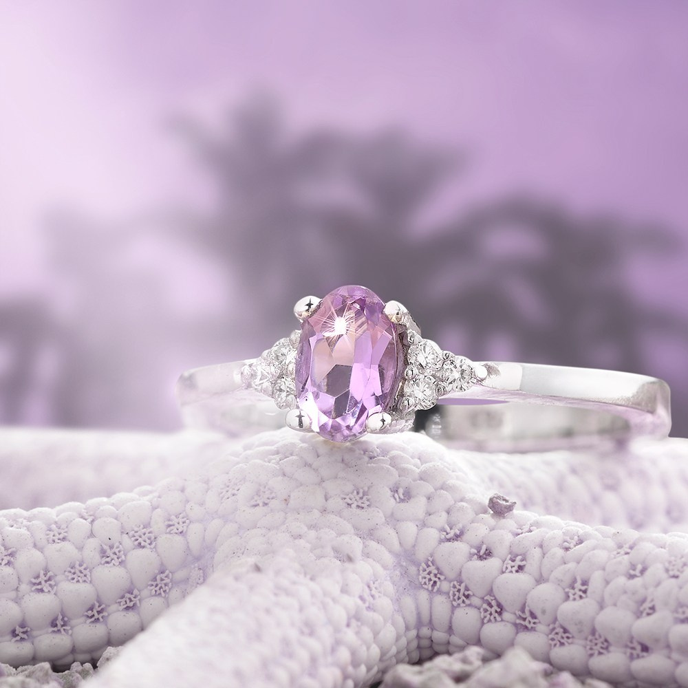 Kompozit morske zvezde i zlatnog prstena sa ljubičastim dragim kamenom.