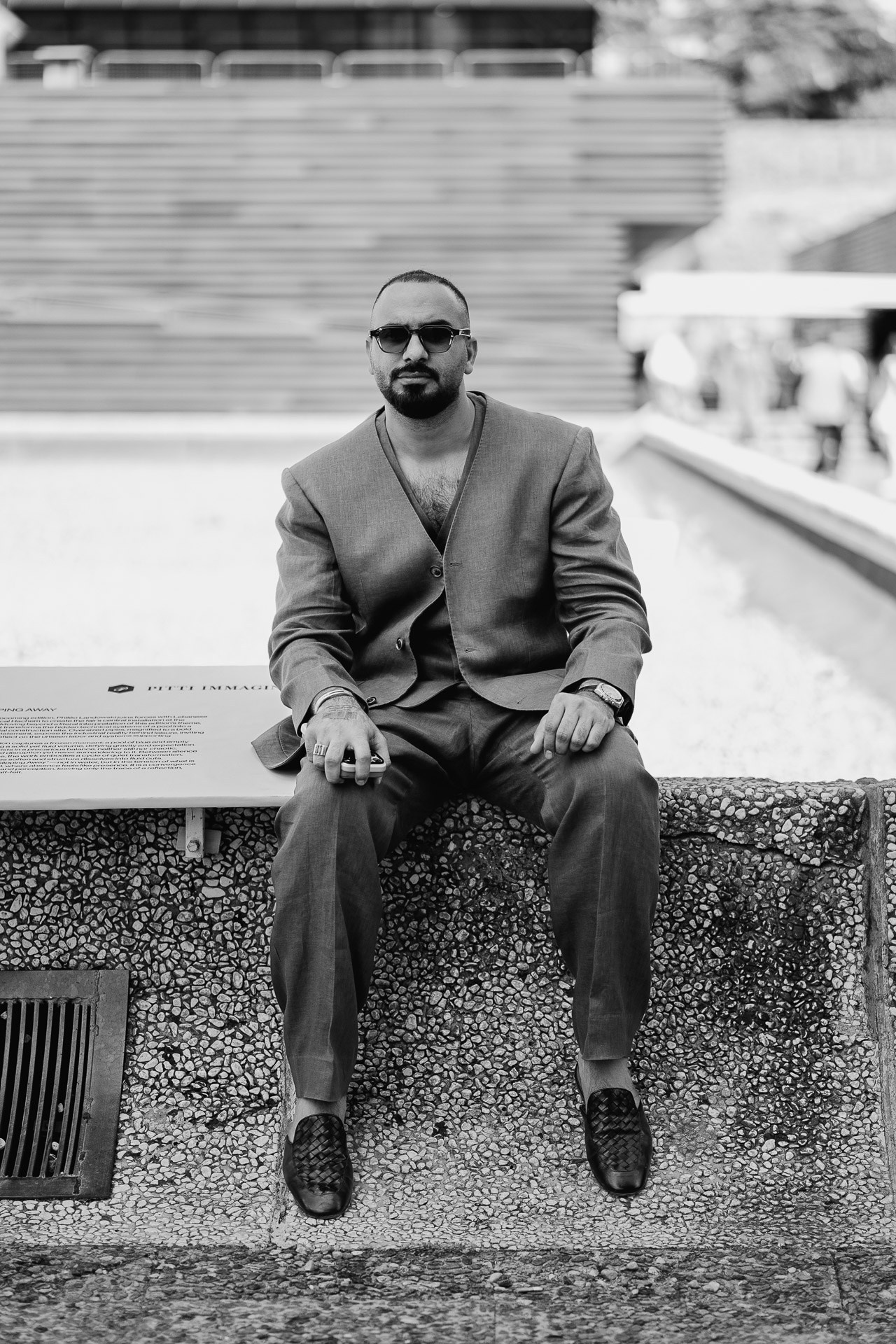 Black and white portrait from Pitti Uomo 110, man in relaxed tailored suit seated in Florence