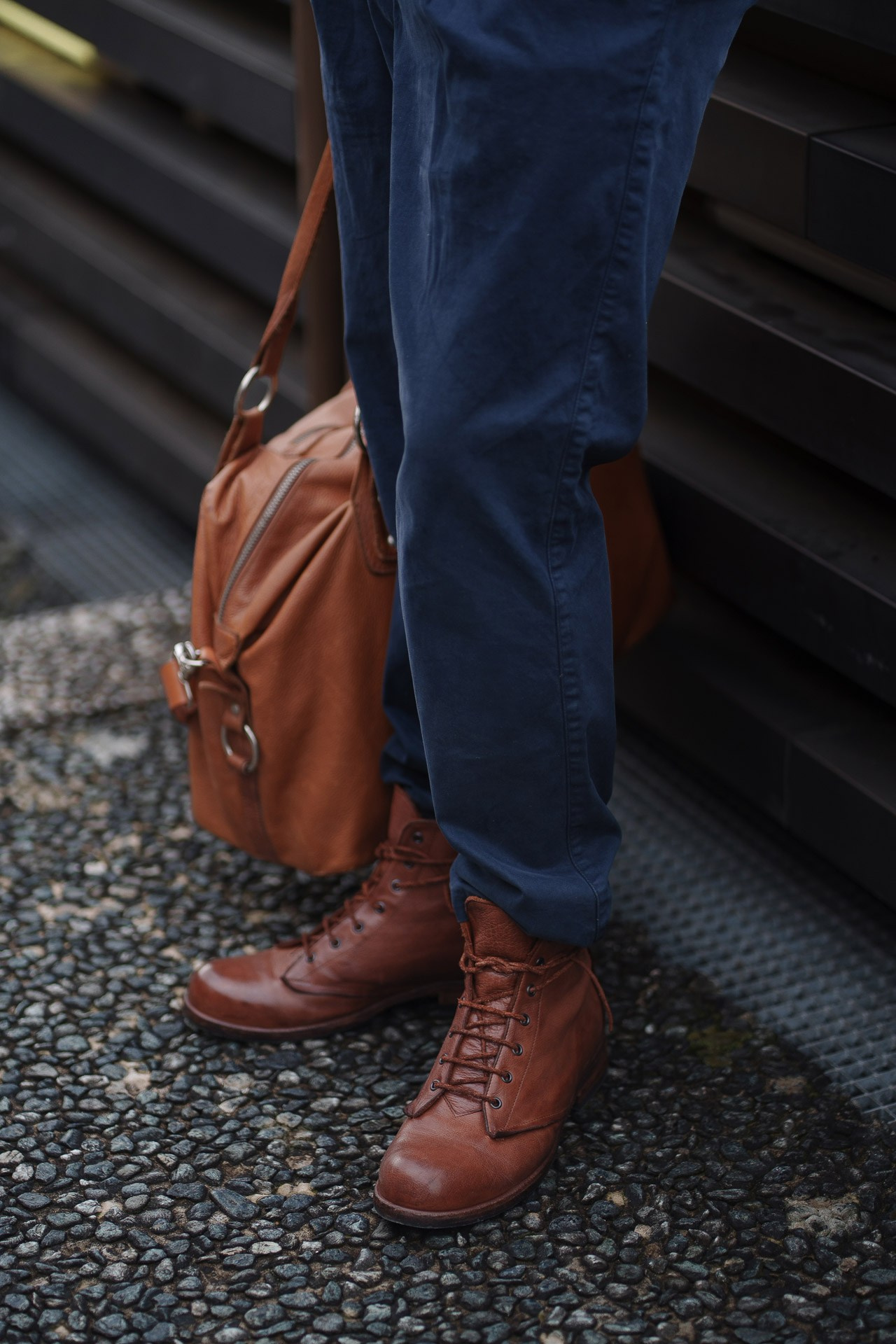 Close up of leather boots and brown bag at Pitti Uomo 109