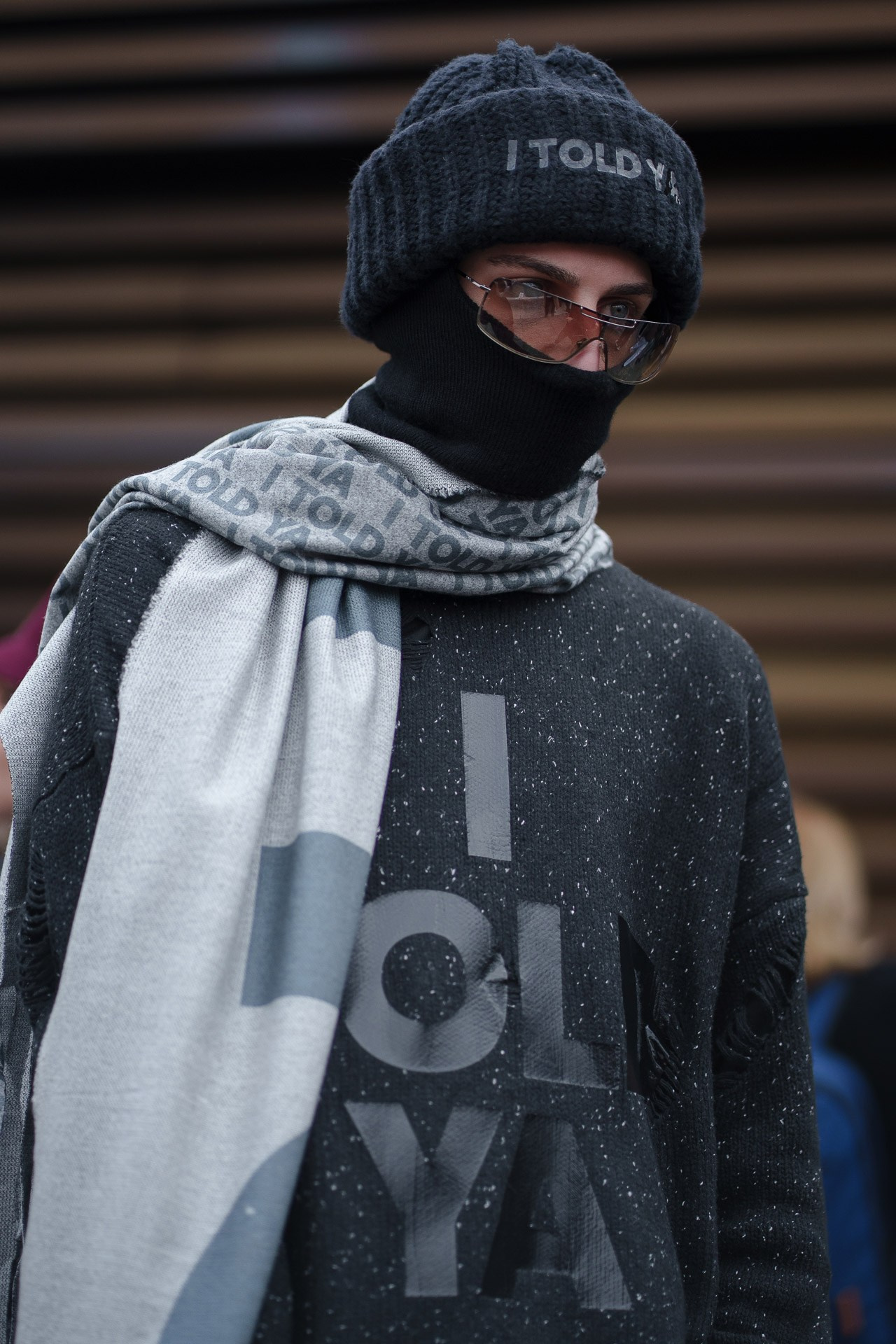Man wearing I TOLD YA scarf and beanie at Pitti Uomo street style