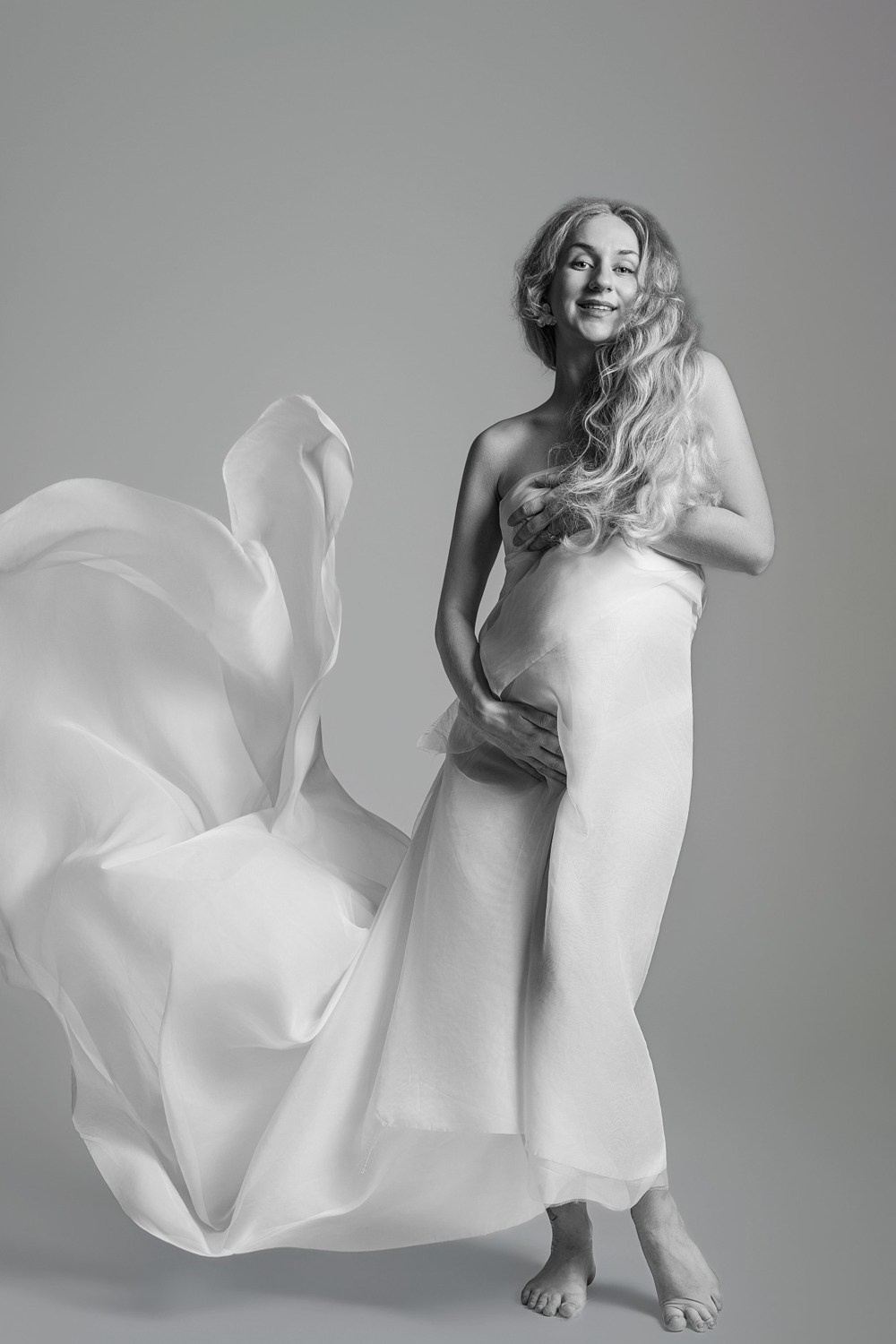 Servizio fotografico maternity artistico a Vicenza, donna incinta con tessuto in movimento