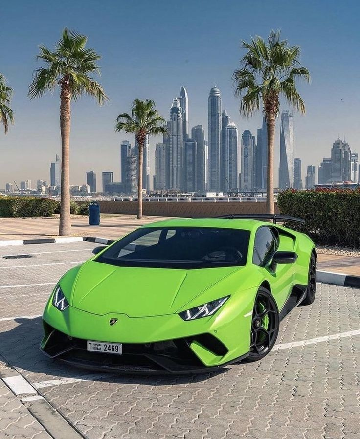 A green Lamborghini on a palm tree in Dubai against the backdrop of skyscrapers. Dubai Marina is located on a green Lamborghini van. “Rent luxury cars in Abu Dhabi and Dubai for exclusive photoshoots and video production.”
