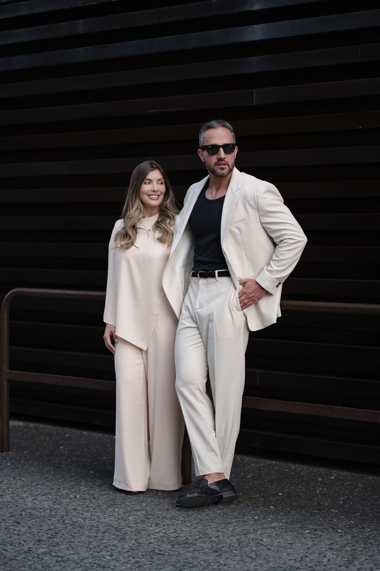Pitti Uomo 110 couple portrait, guests in cream and white outfits outside Fortezza da Basso