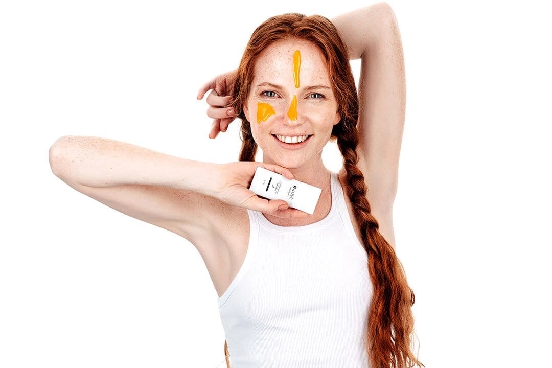 Model with loose hair, conveying a sense of freedom and natural beauty. Her makeup is minimal, allowing her skin to glow and her features to stand out. The background is unobtrusive, focusing the viewer's attention on her expressive face and flowing hair. This photograph celebrates the simplicity and elegance of natural beauty.