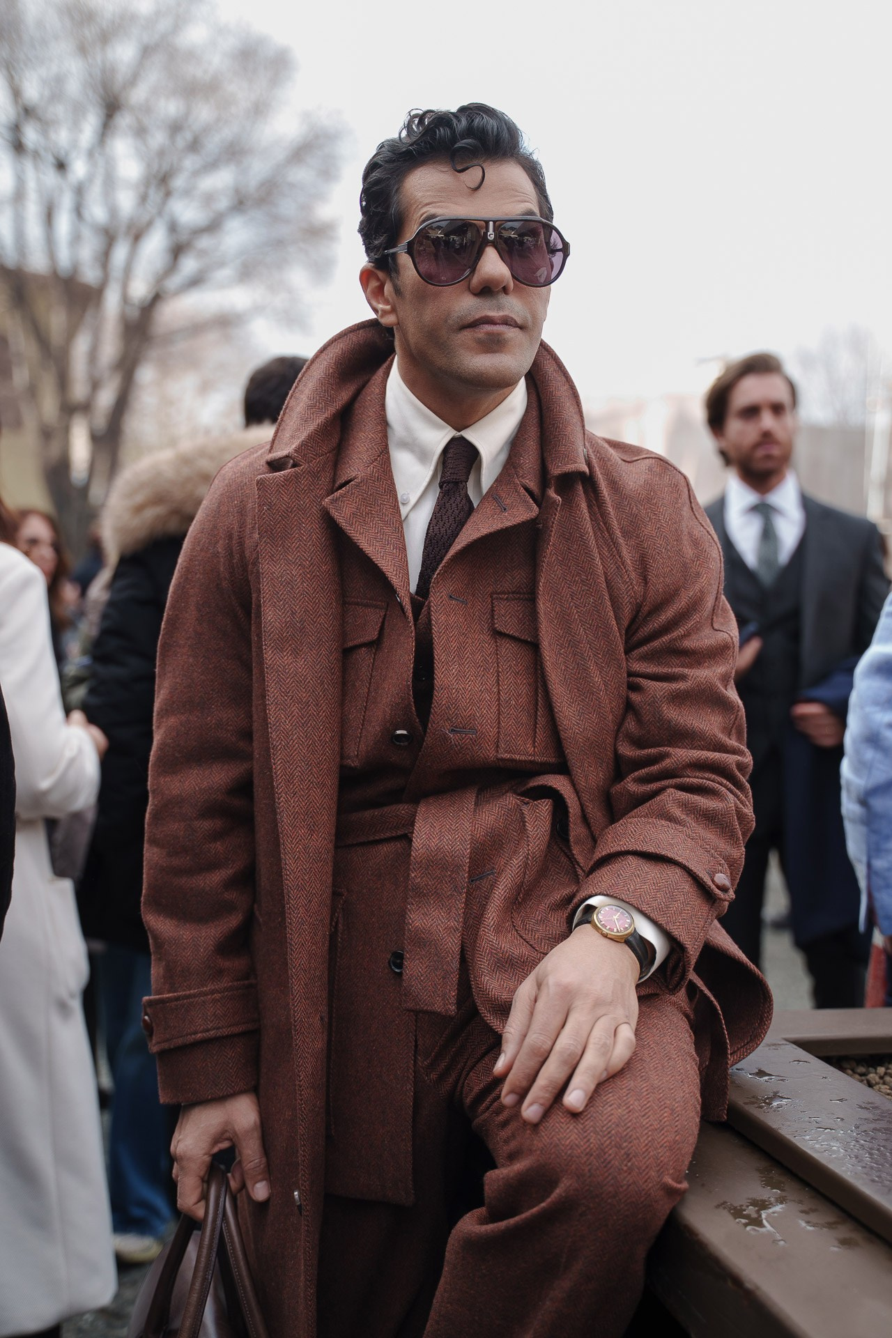 Man in brown belted coat wearing sunglasses at Pitti Uomo 109