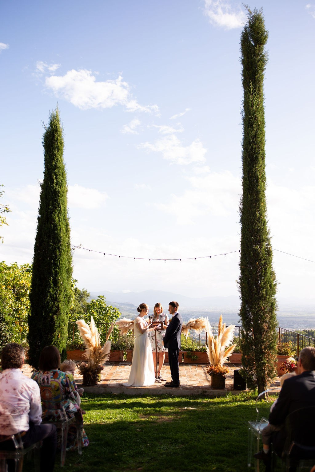 Outdoor wedding ceremony in an elegant Italian villa surrounded by cypress trees