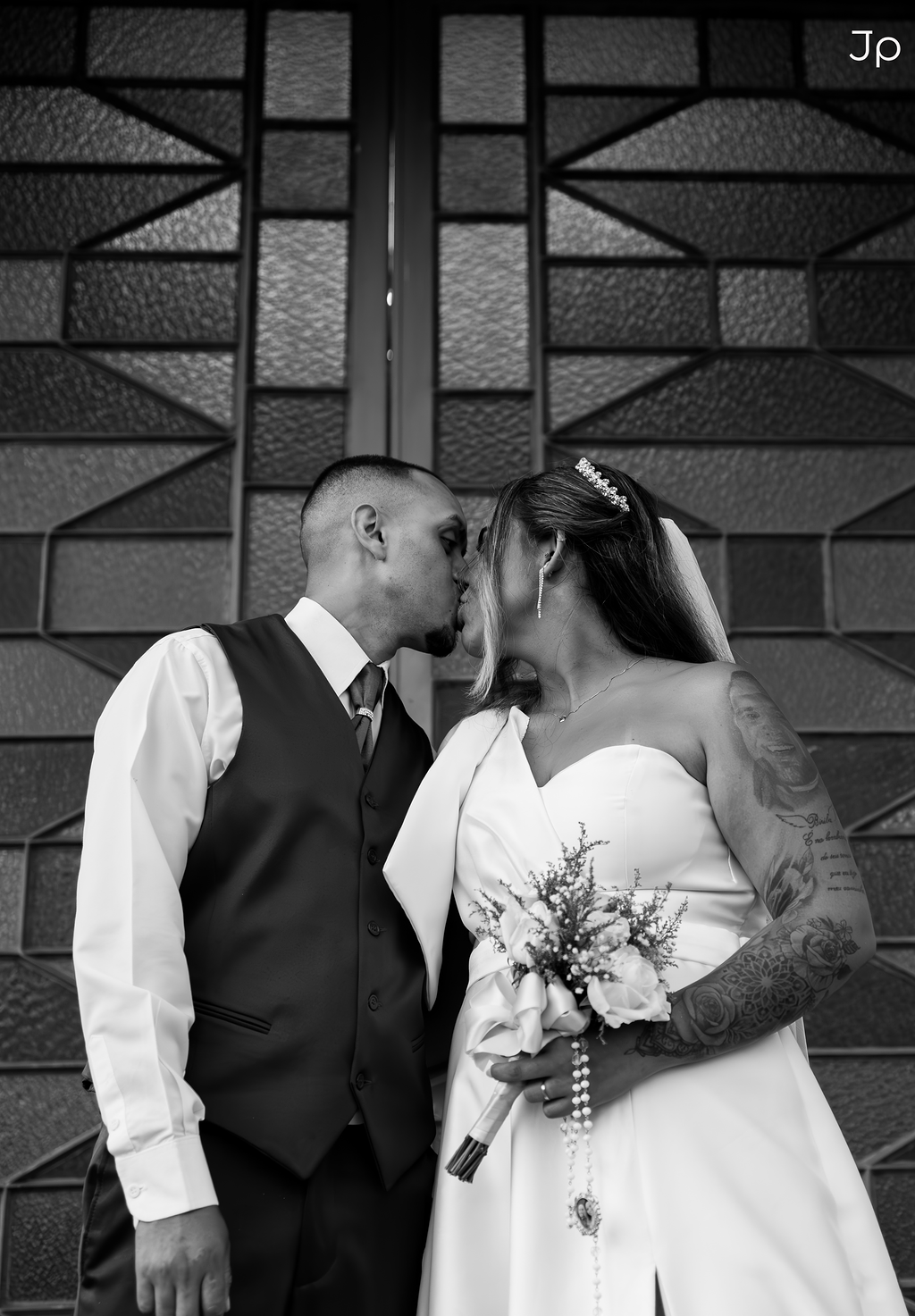 Noiva encosta a cabeça no ombro do noivo sorrindo.