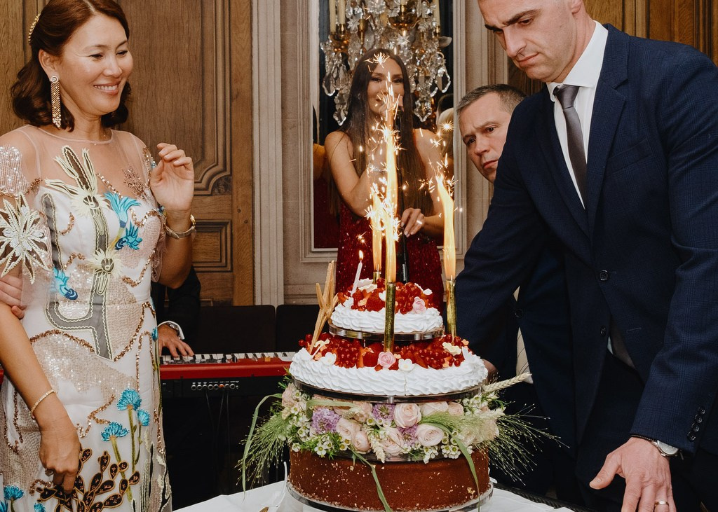 Guests gathered around a birthday cake at a private celebration in Paris