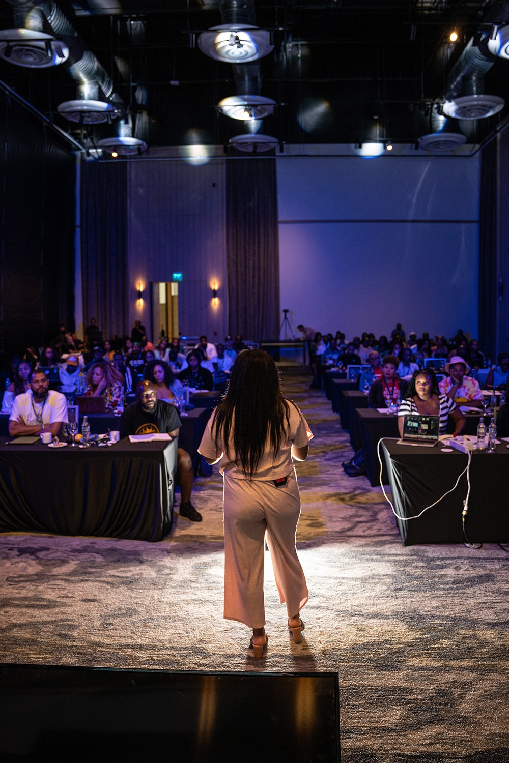 Speaker outlining concepts as audience watches the stage.
