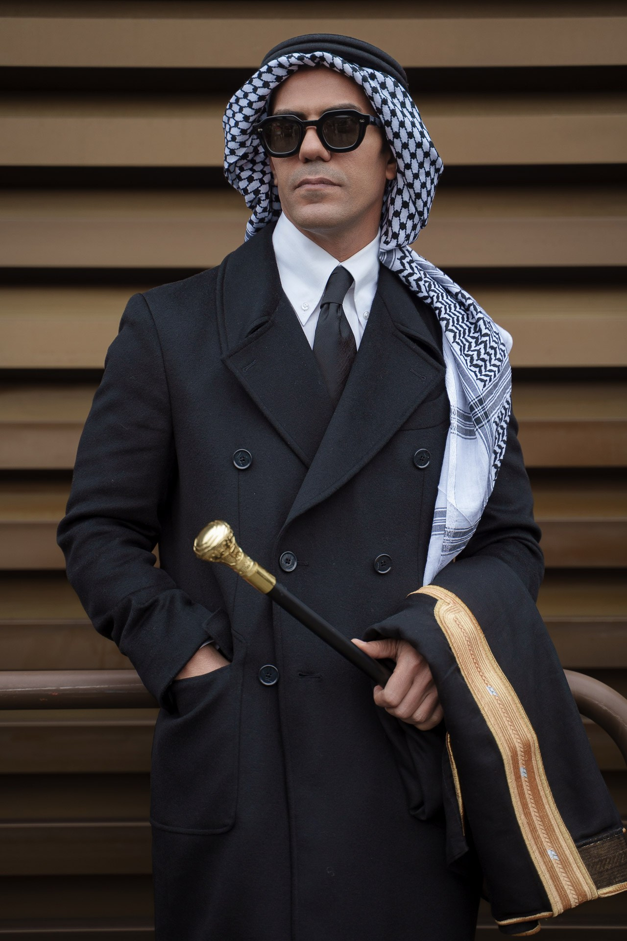 Portrait of stylish man wearing sunglasses and keffiyeh at Pitti Uomo Florence
