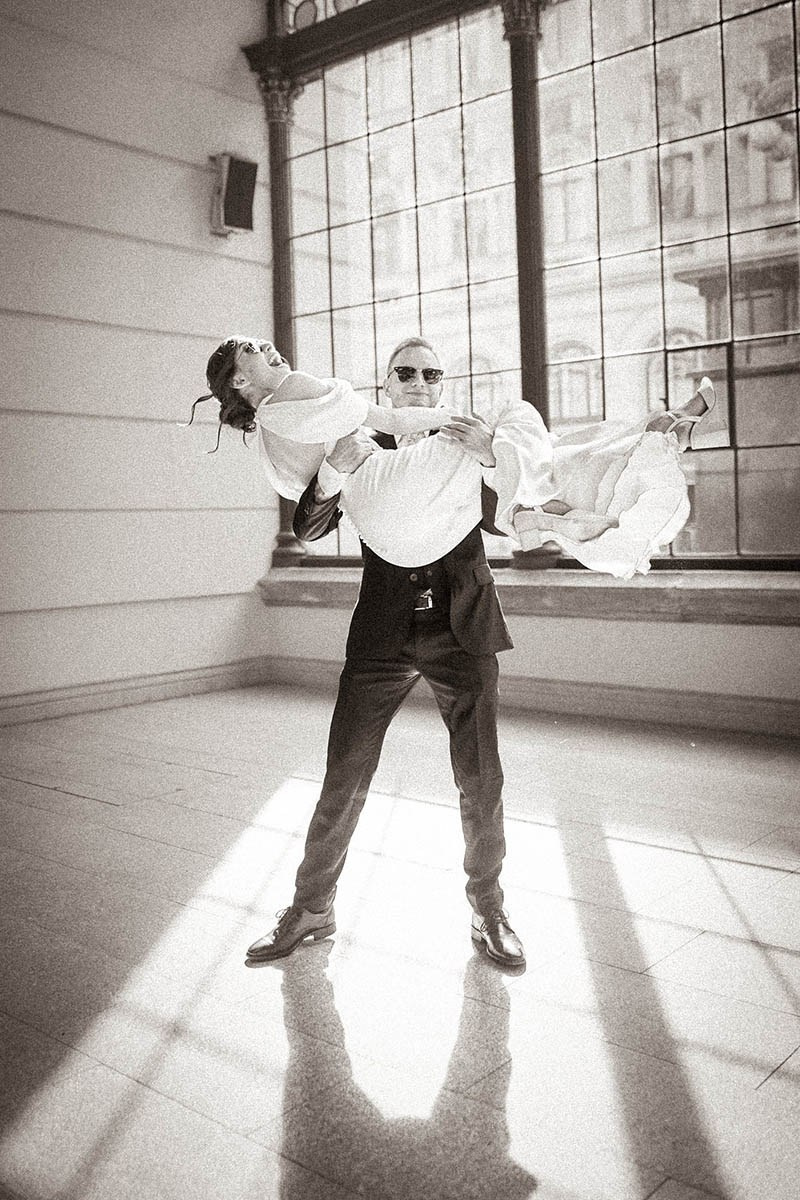 Groom lifting laughing bride at Praha-Masarykovo Train Station, Prague 