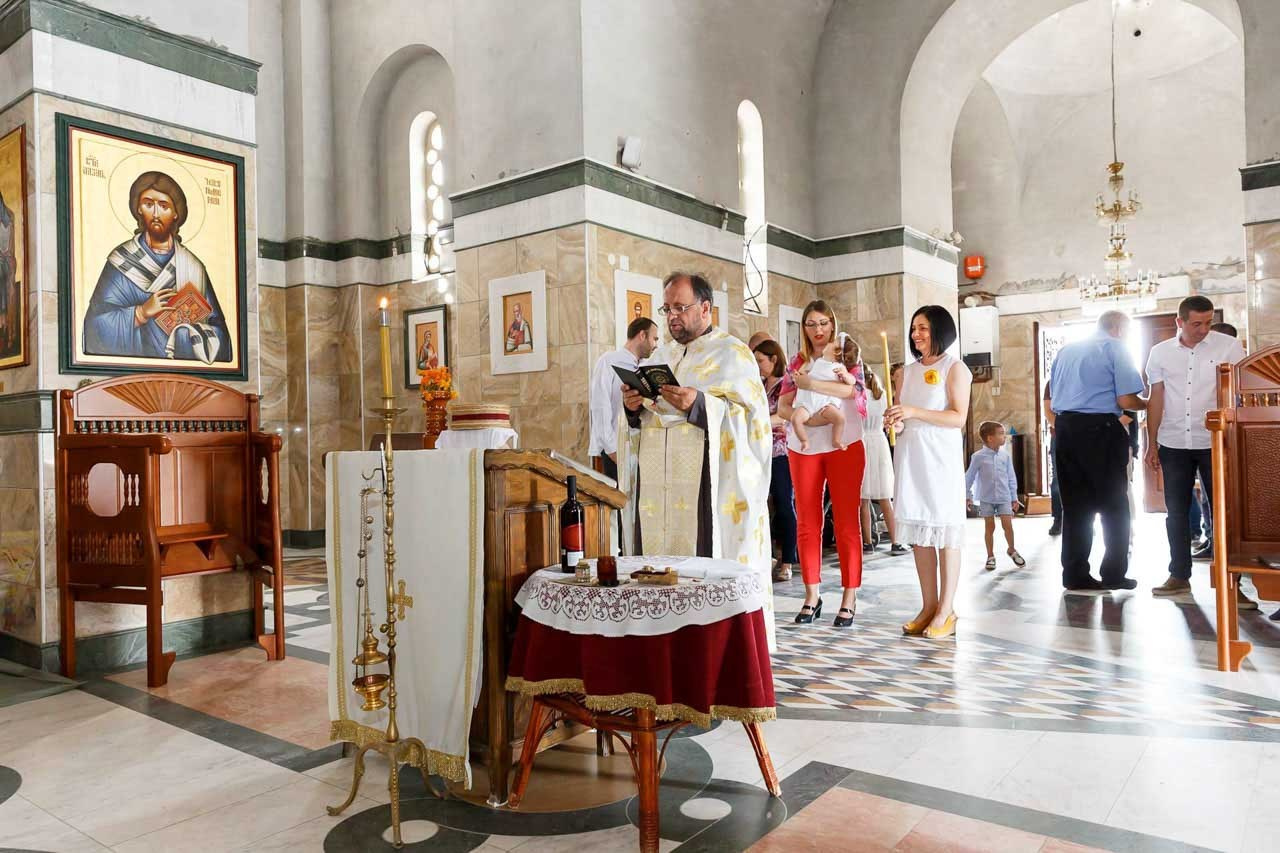 Sveštenik vodi ceremoniju krštenja u autentičnoj crkvi.