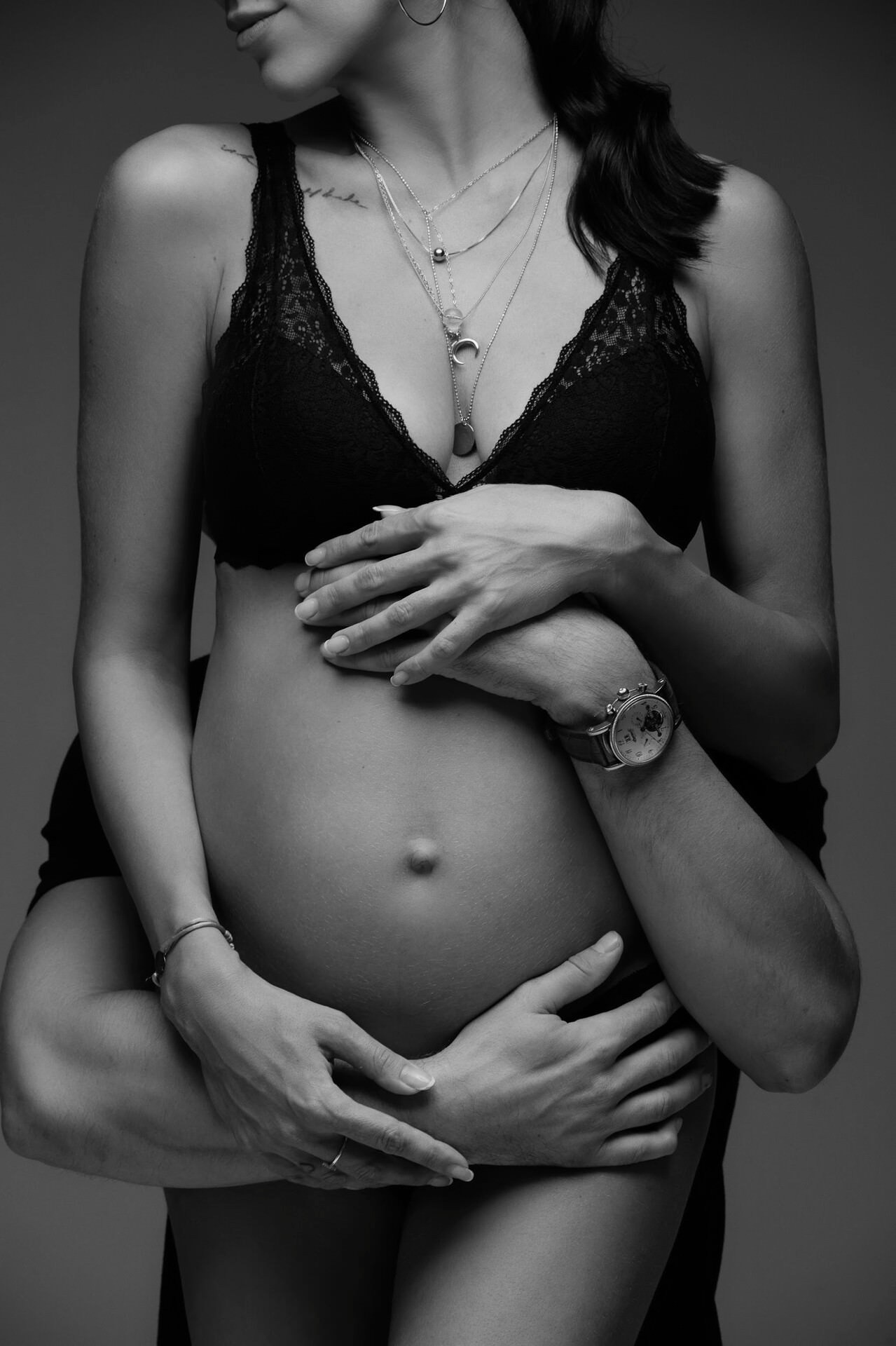 Schwangerer Bauch mit Händen des Ehemanns