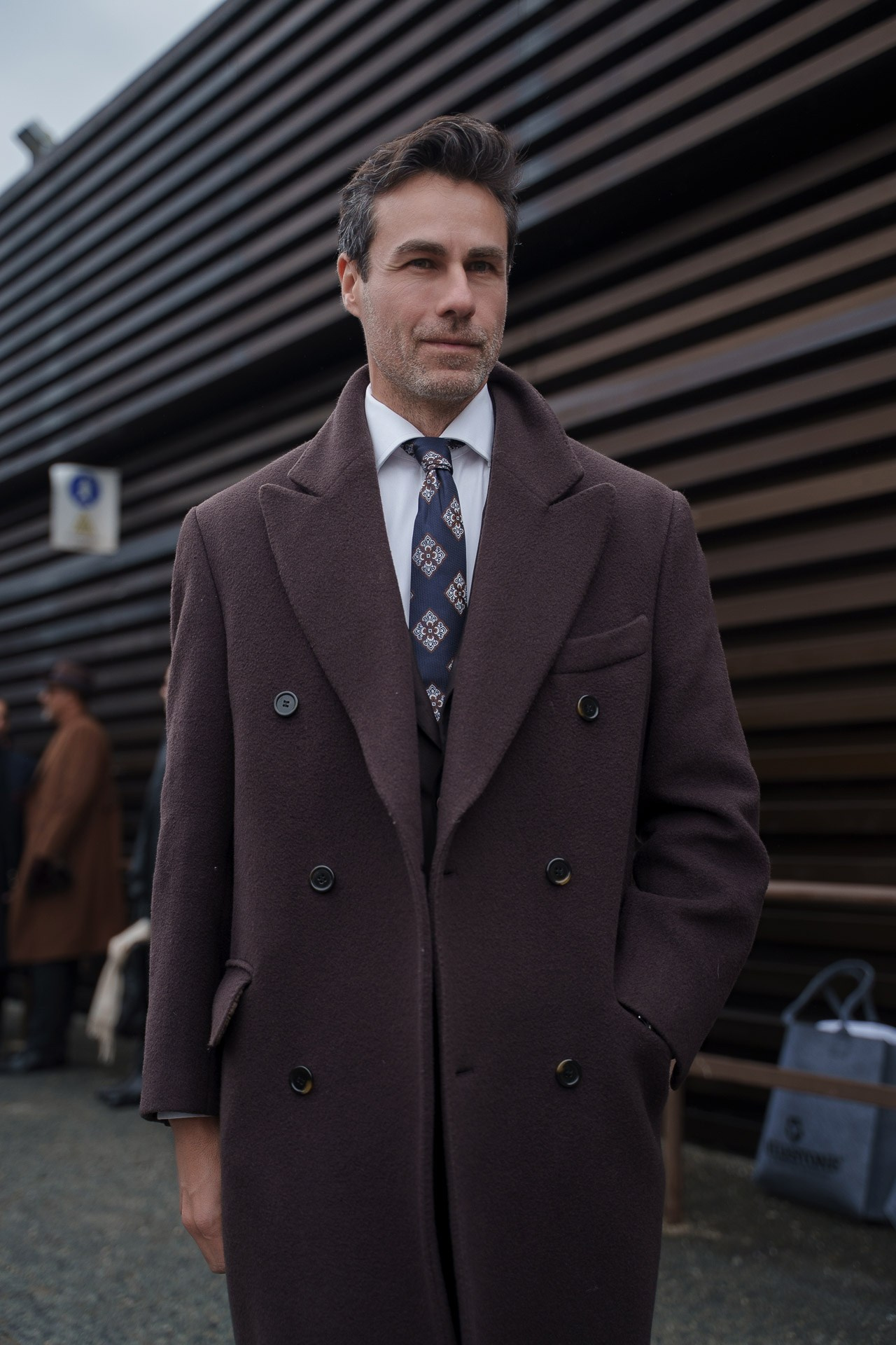 Portrait of man in elegant brown coat during Pitti Uomo 109 street style