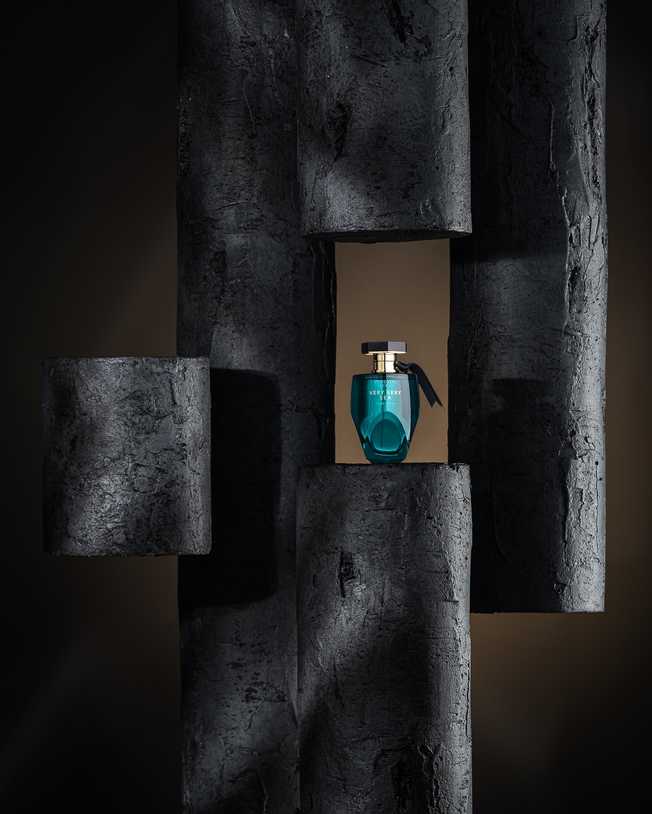 Conceptual fragrance still life with grey cubes and blue bottle — artistic studio photography.