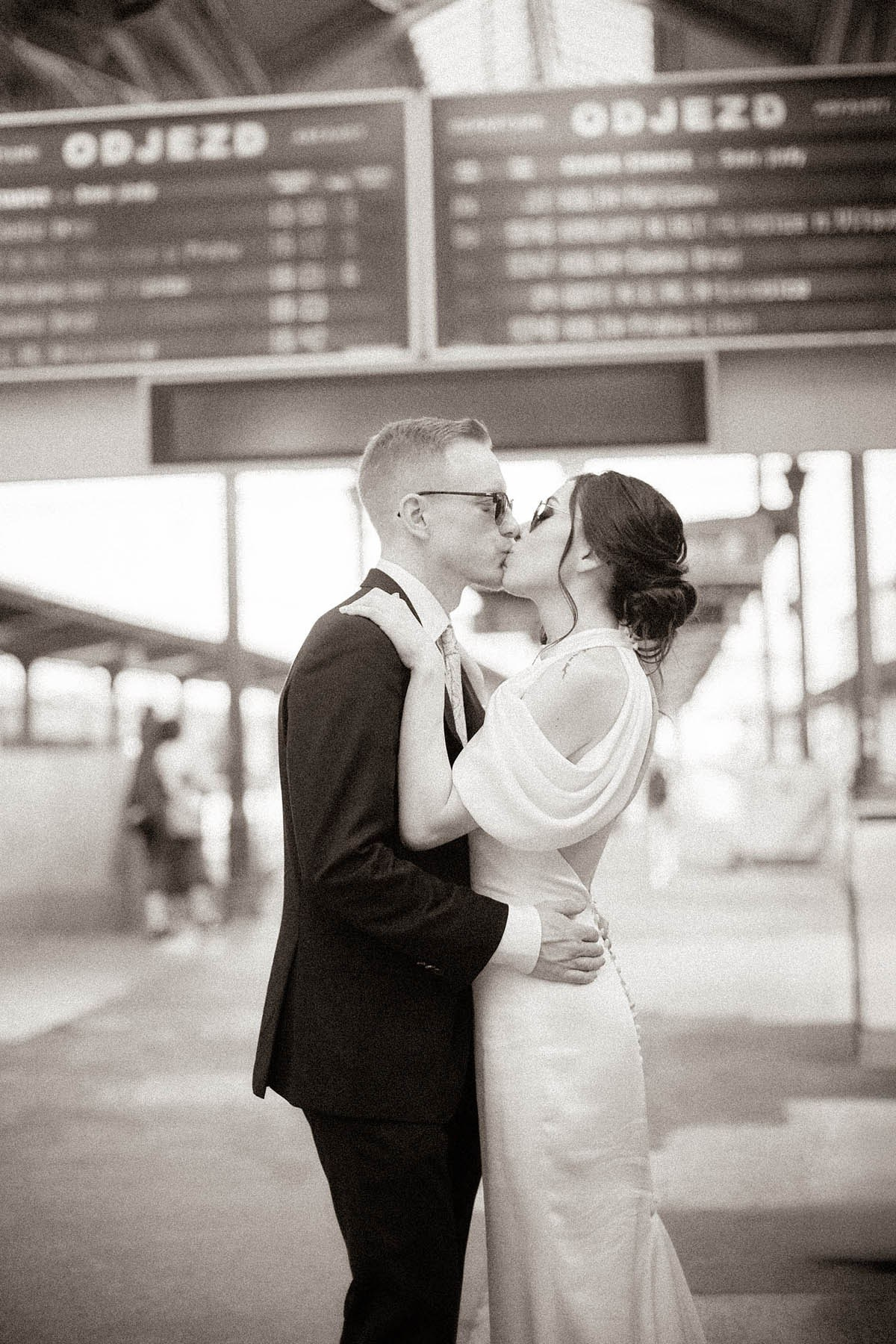Bride and groom sharing a long kiss at Praha-Masarykovo Train Station, Prague