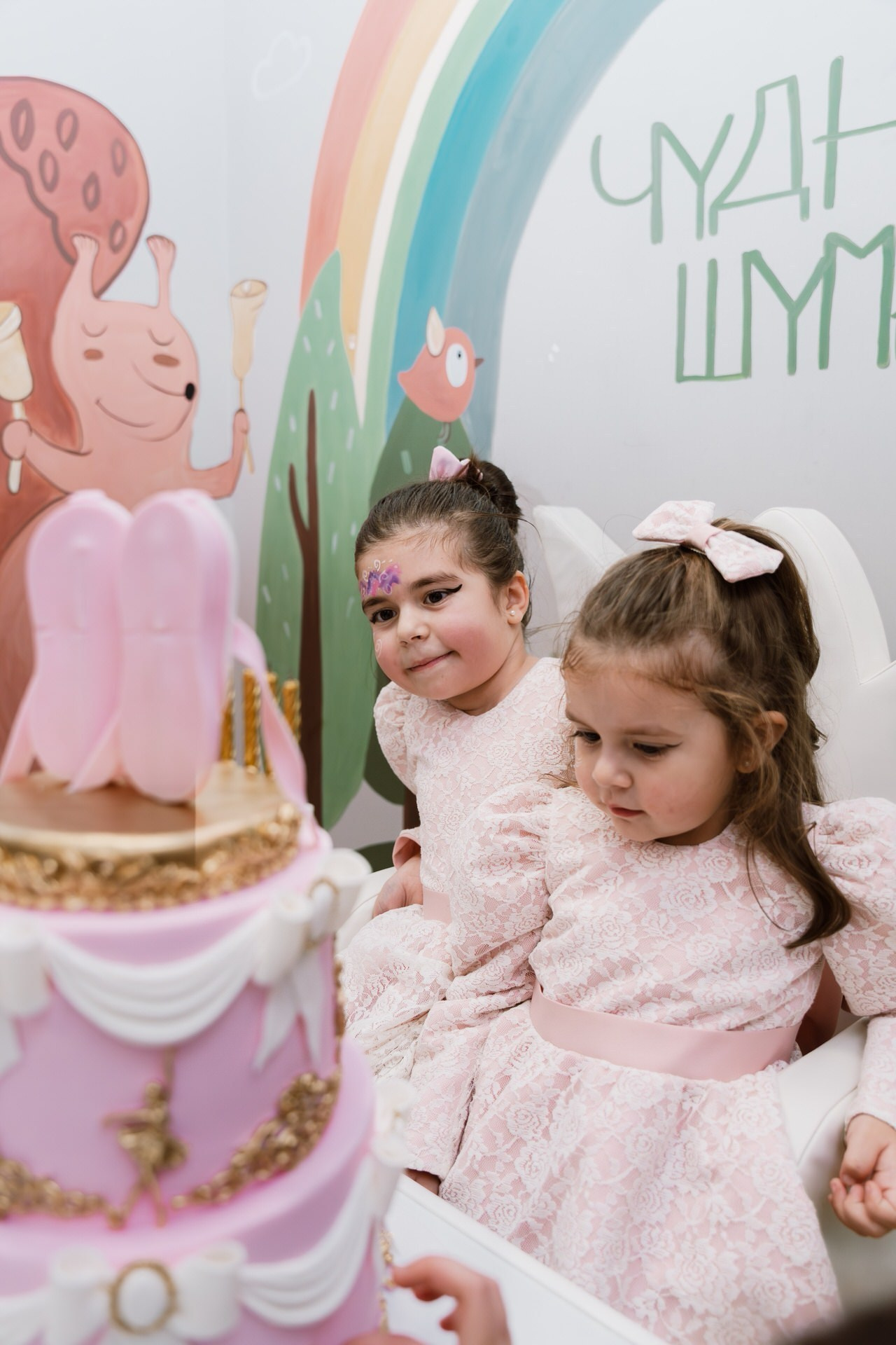 dve devojčice gledaju zadovoljno u rođendansku tortu na sprat