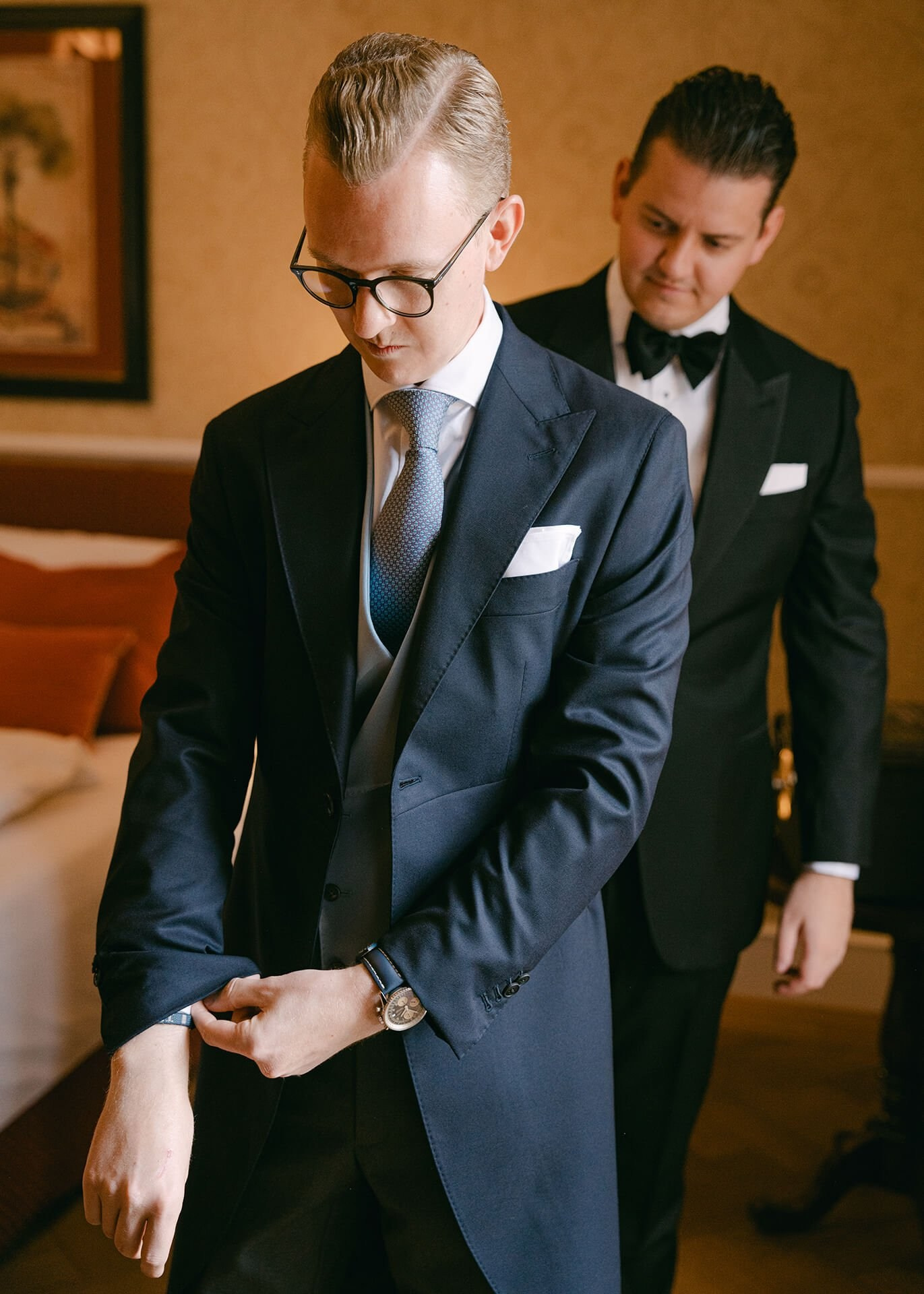 Groom adjusting cuff links in a suit, getting-ready portrait