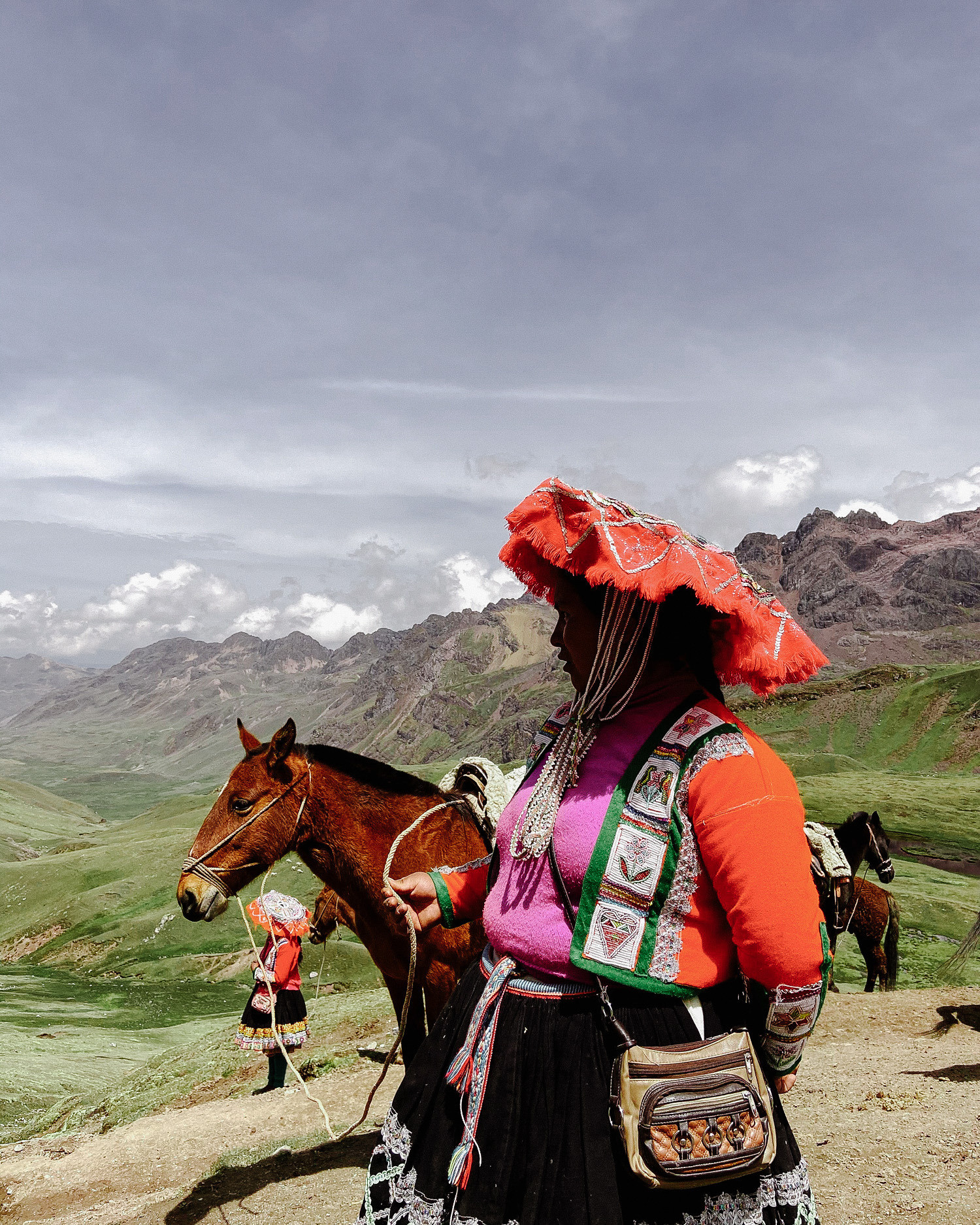 Бабушка одетая в традиционную Перуанскую одежду позирует фотографу. 