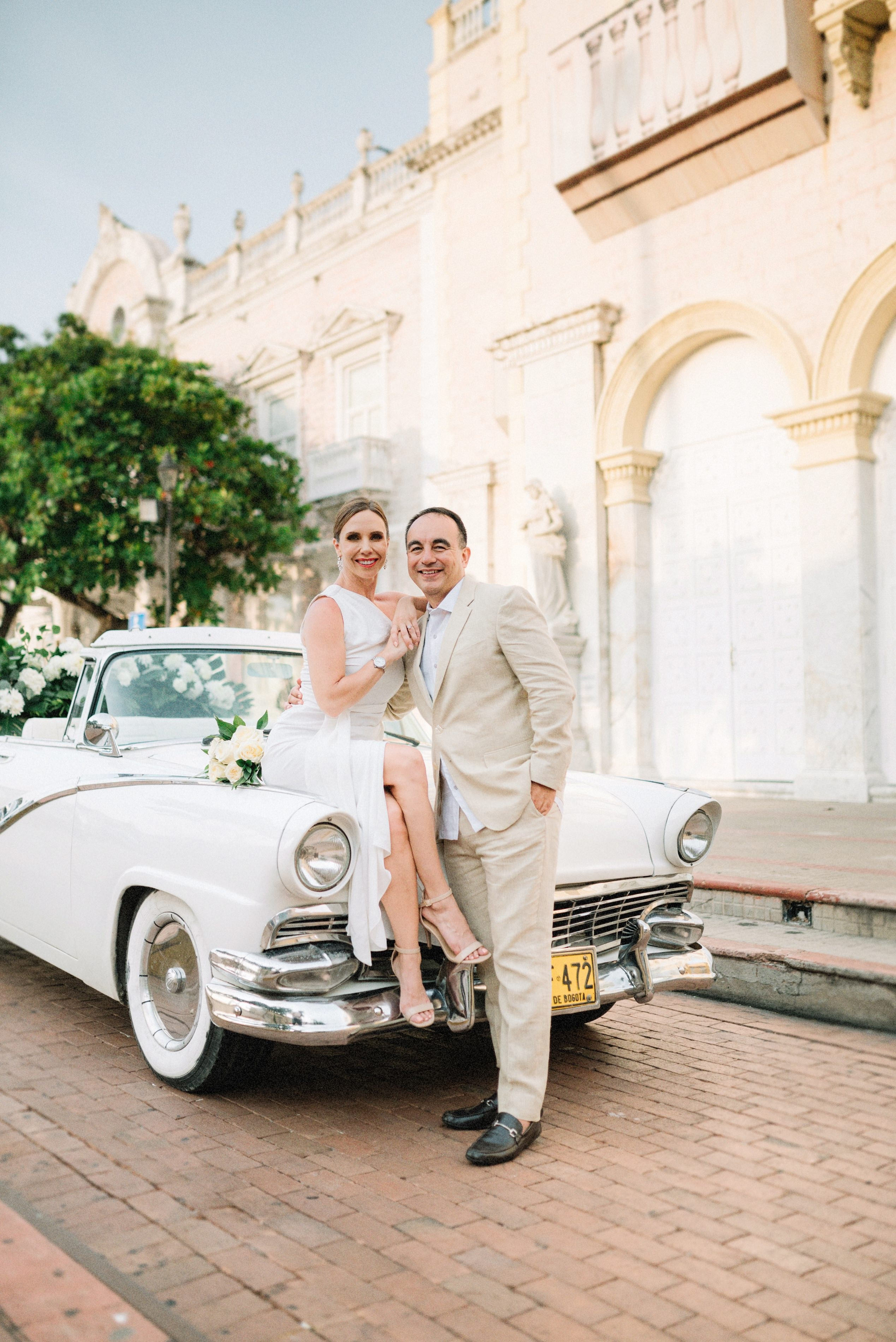 Bride and groom in front of a classic car in Cartagena, destination wedding photography