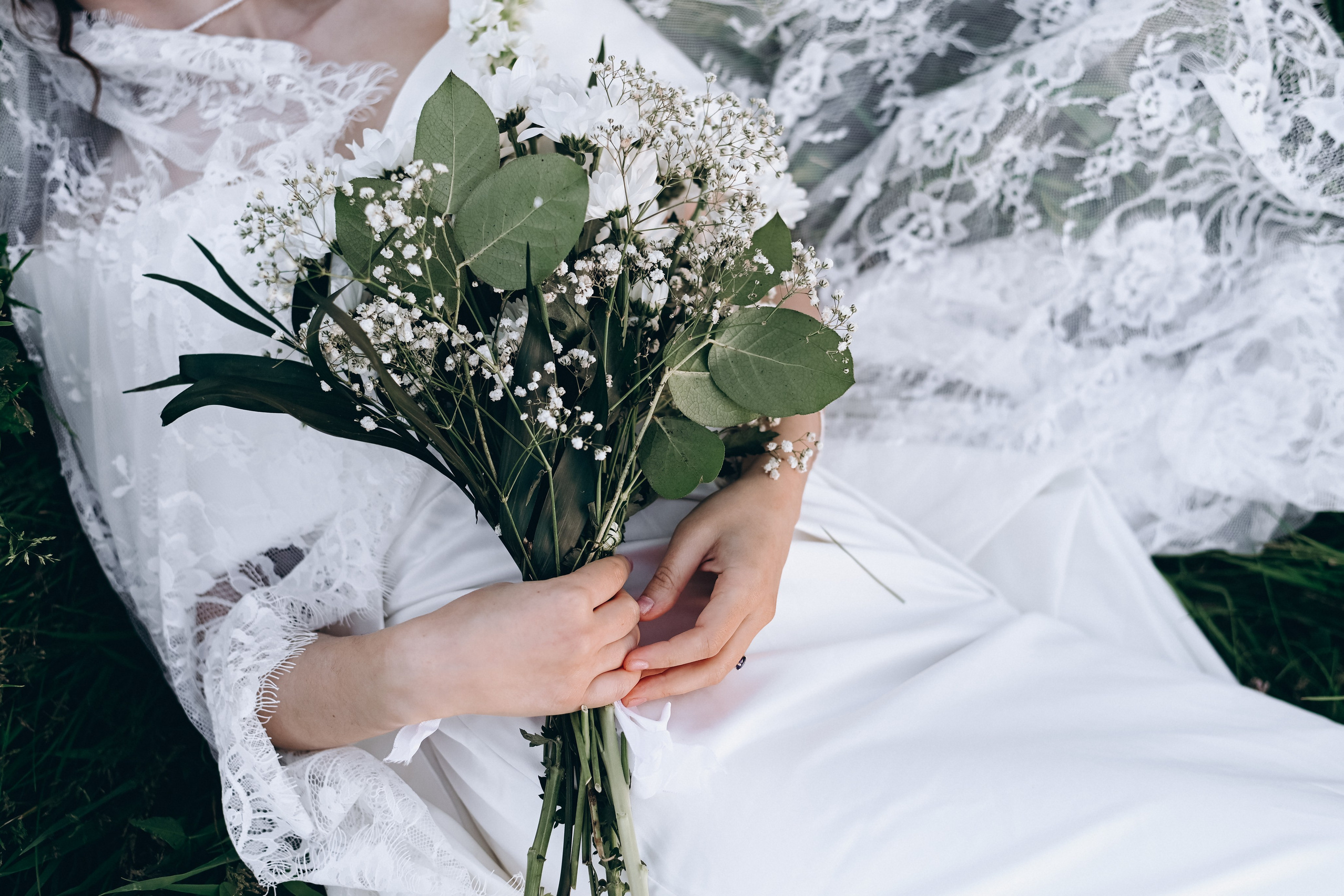 Braut in elegantem Hochzeitskleid mit Blumenstrauß während eines Fotoshootings
