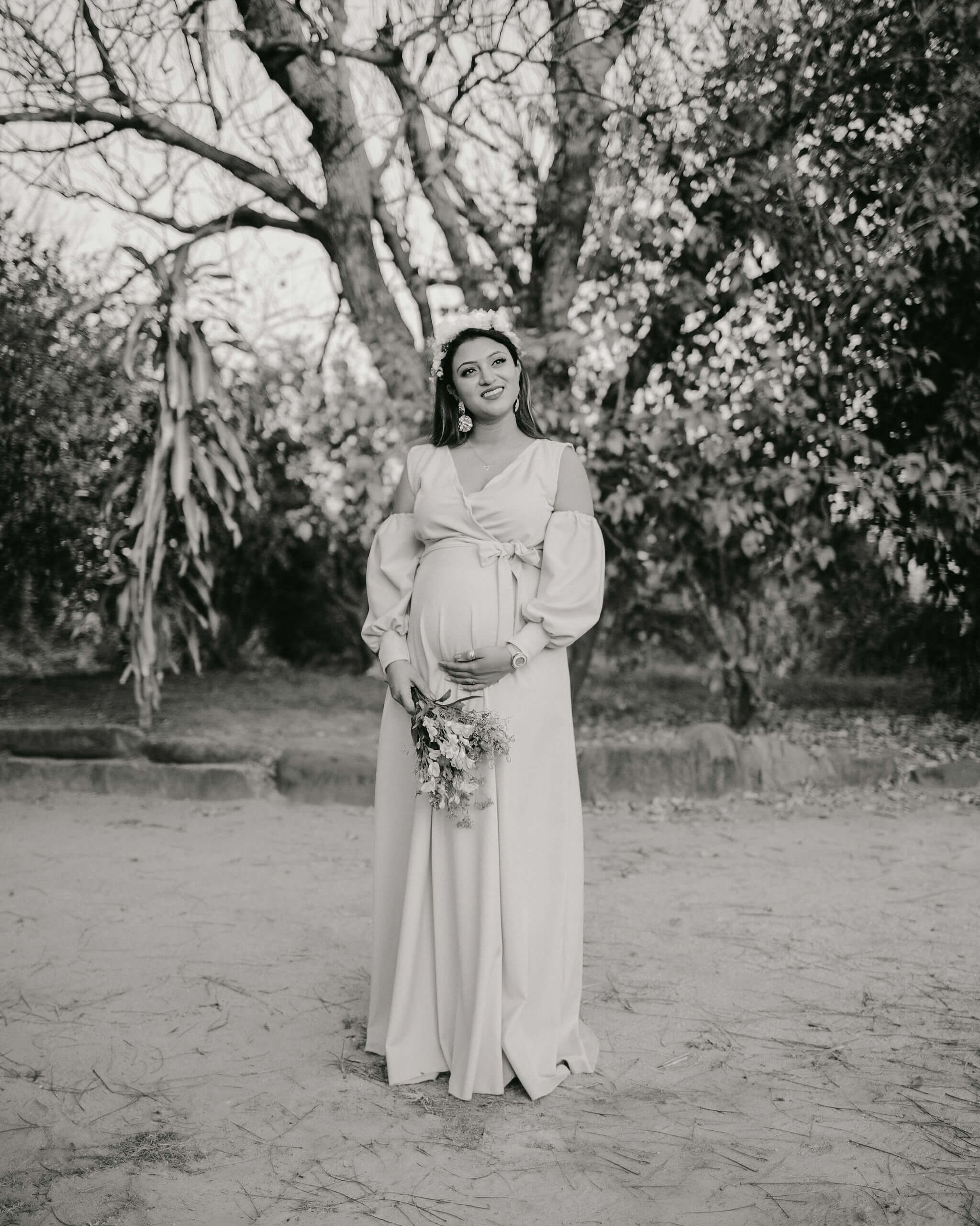 Timeless maternity photoshoot in tree-lined path, black & white elegance in Mombasa, Kenya.