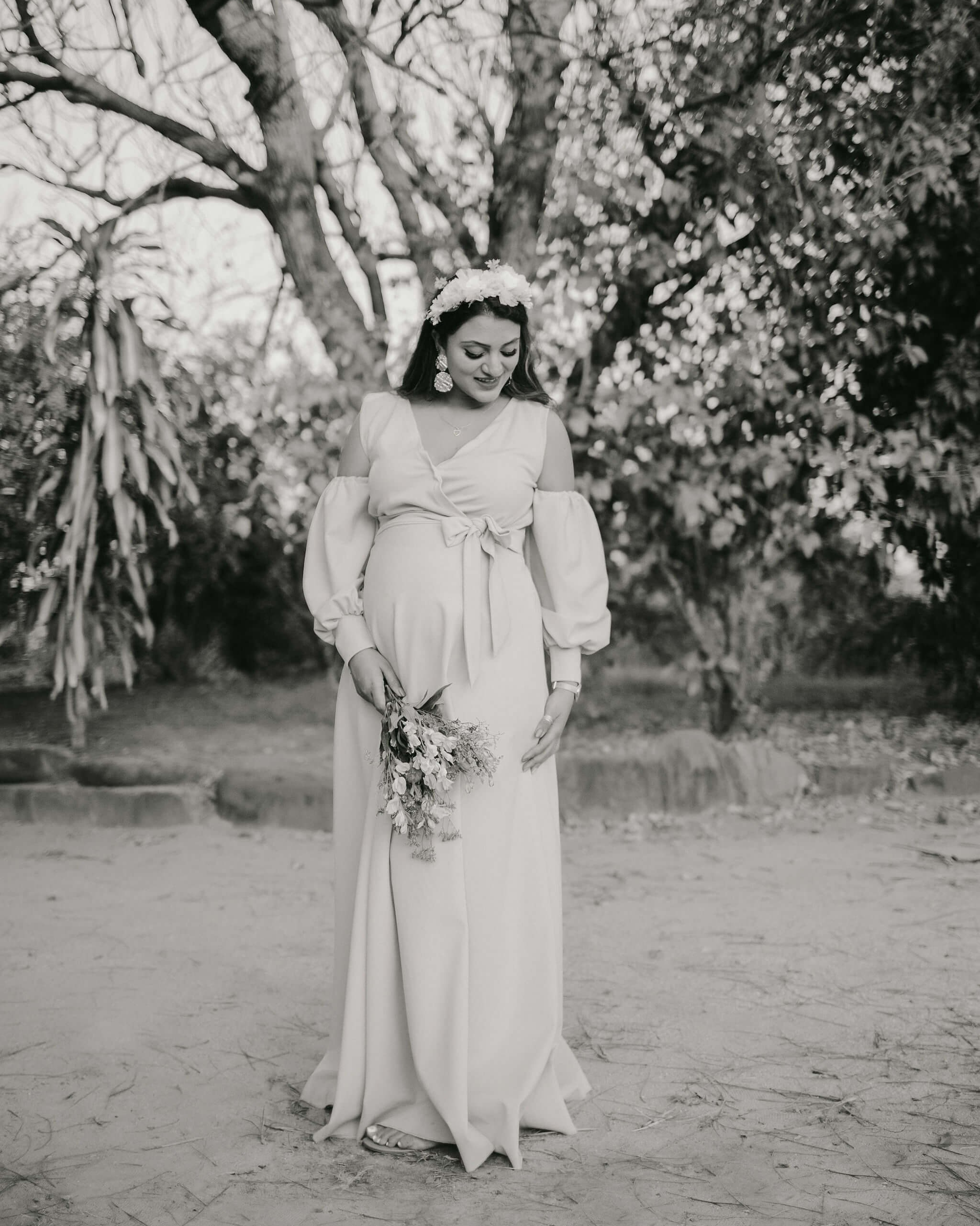 Black and white Kenya maternity photo with graceful mother under blooming trees, perfect for vintage albums.