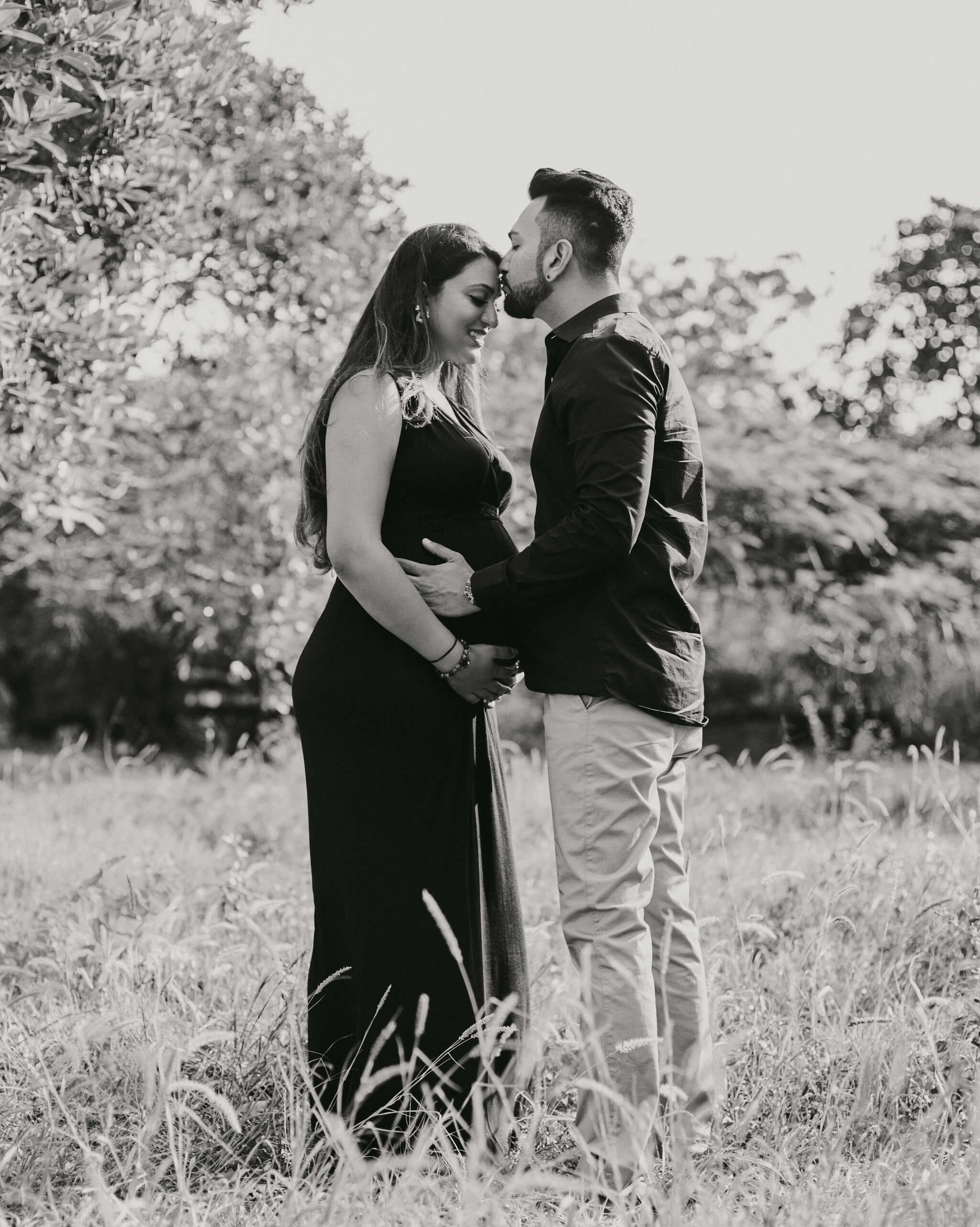 Kenya garden maternity photoshoot in B&W — couple looking lovingly at each other, soft foliage background.