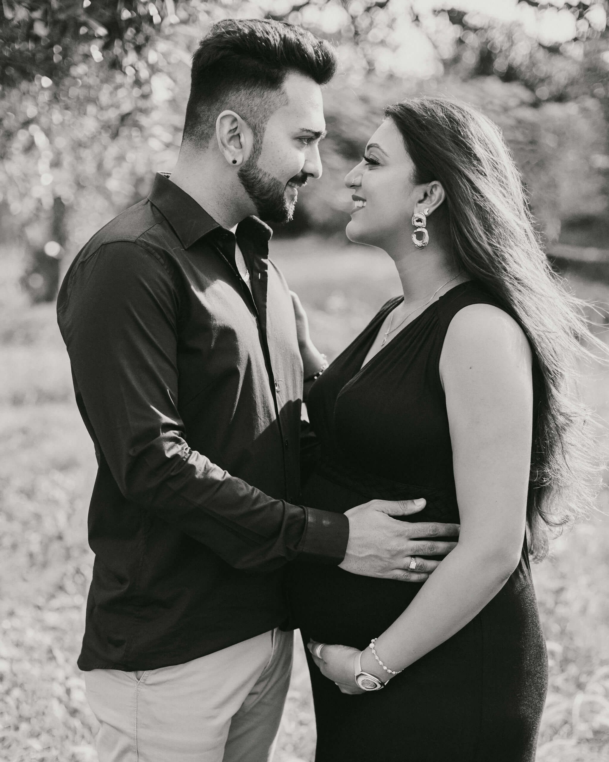Romantic black and white pregnancy portrait with couple embracing in a natural garden setting, Mombasa coast.